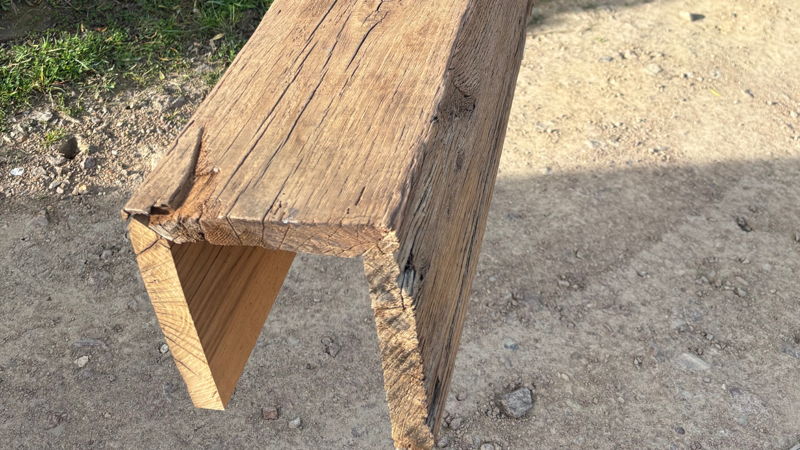 Close-up of the end of a reclaimed European oak box beam showing aged grain, weathered texture and natural timber character.