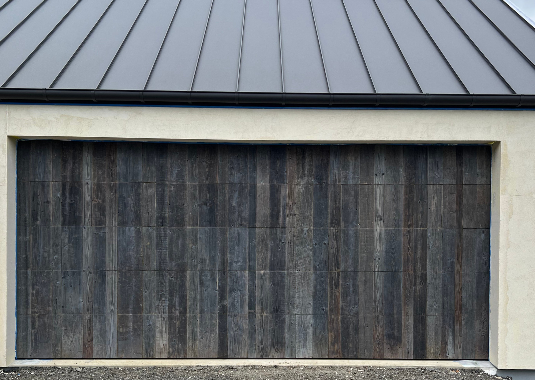 Reclaimed European oak boards used as vertical garage door facings with dark aged texture and natural tonal variation.