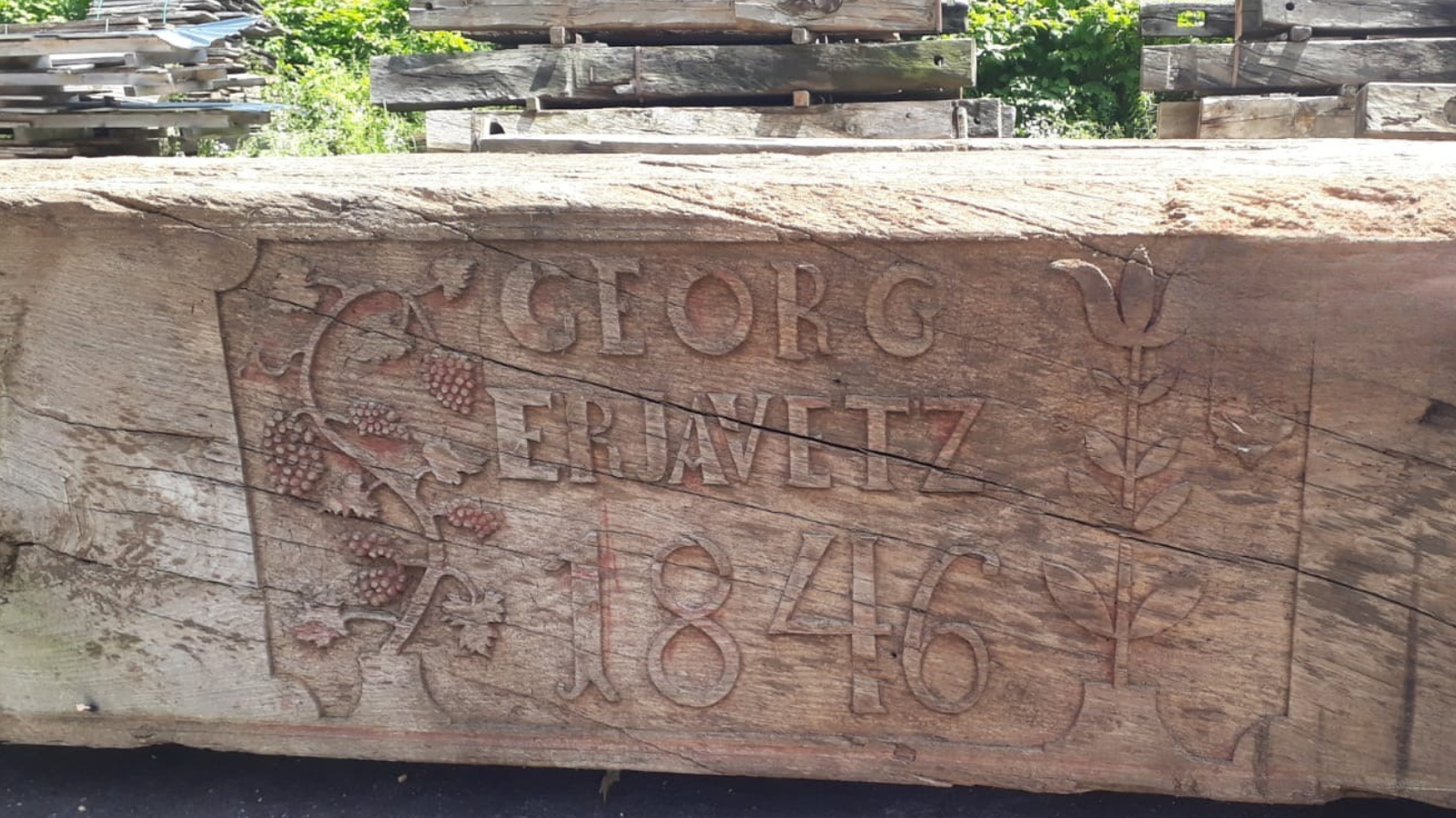 Historic reclaimed oak beam with decorative carving and the date 1846.