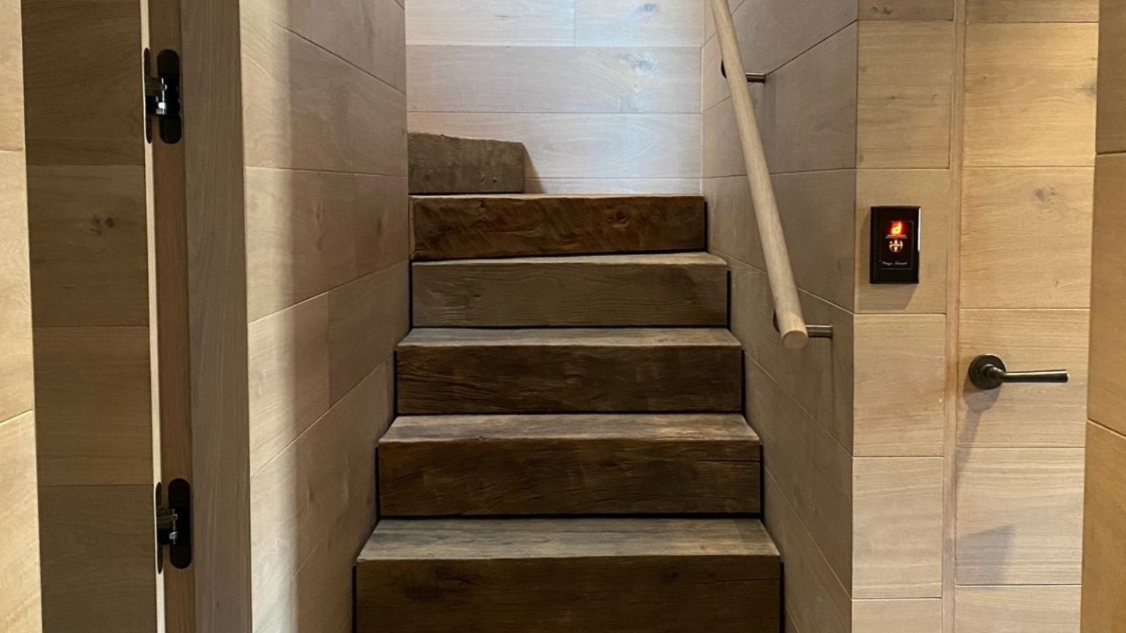 Custom oak stairs with reclaimed oak treads and timber wall lining, showcasing warm joinery detail in a New Zealand interior.