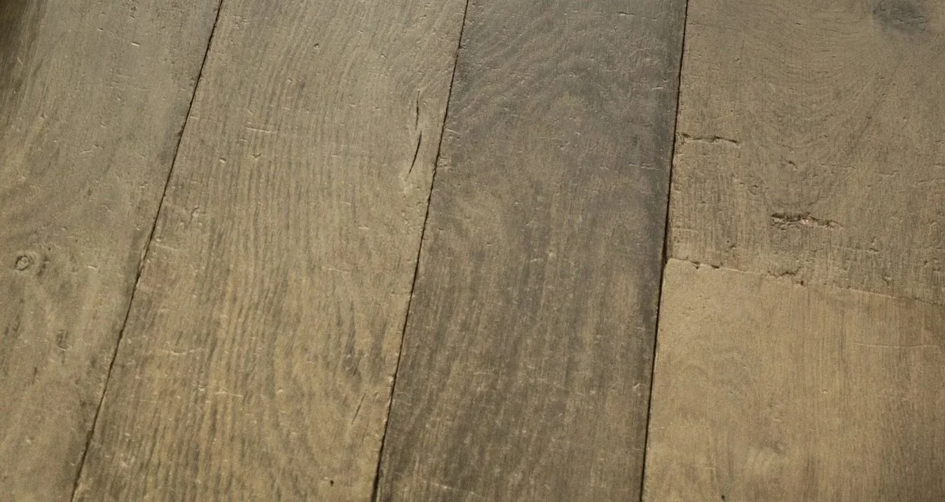 Close-up of a wooden floor with planks in various shades of brown.