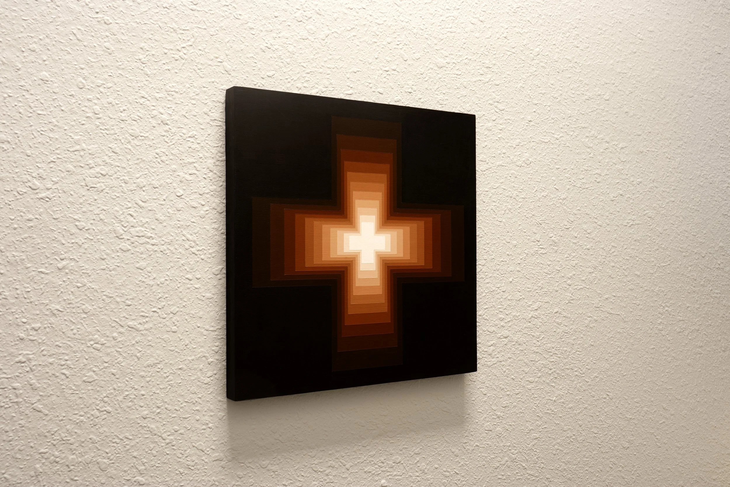 Symmetrical geometric forms rendered in a gradient of dark mahogany brown to soft, warm light tints, contrasting against a stark background.jpg