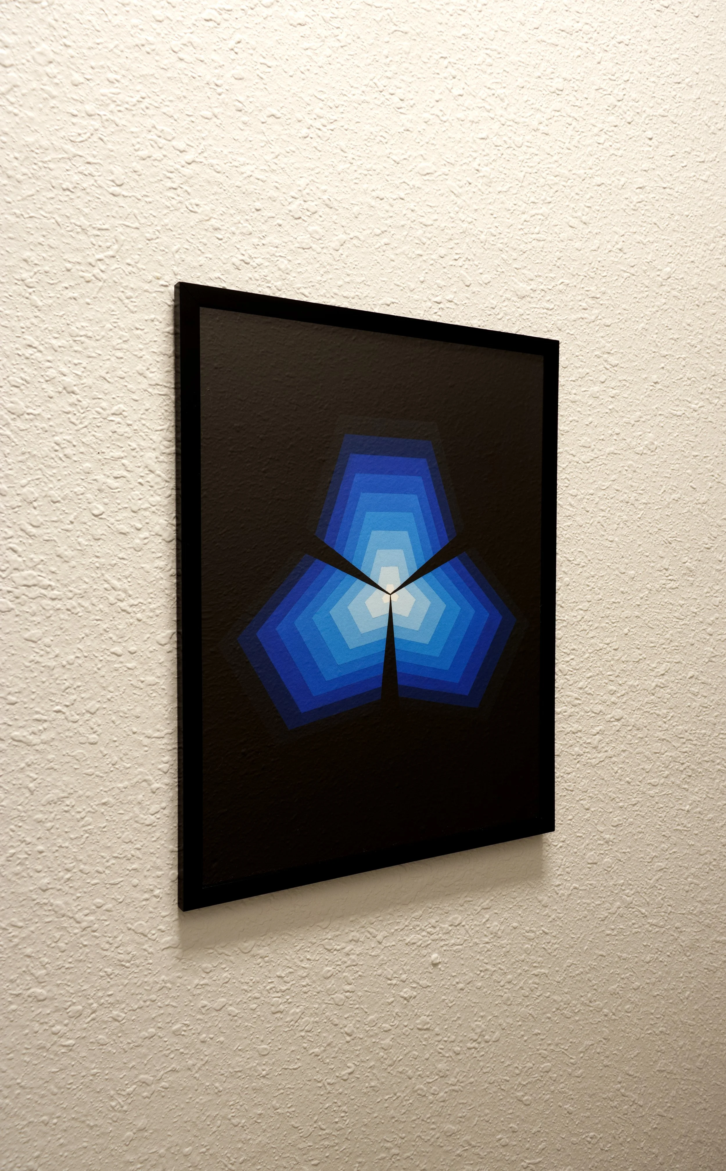 Layered pentagonal shapes on a canvas rendered in a gradient of deep navy blue to bright, luminous azure tints with sharp boundaries.jpg