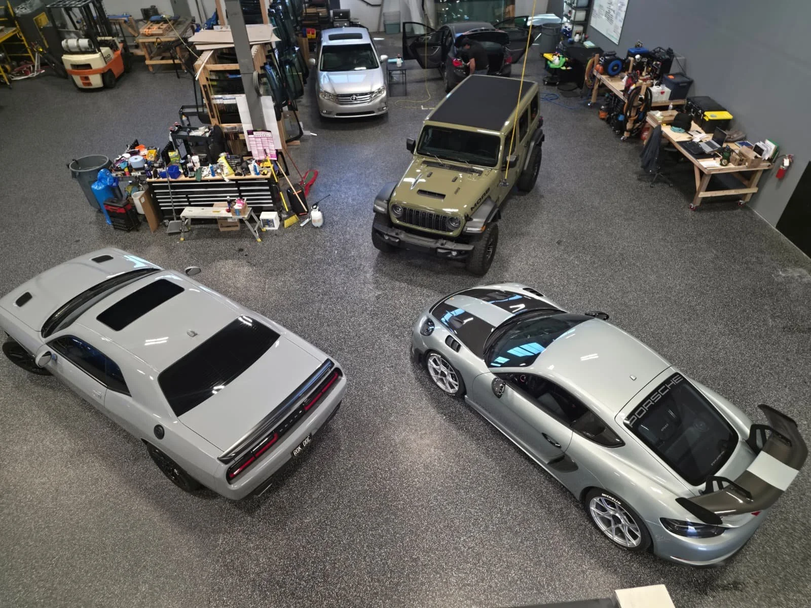 White Tesla inside an auto glass workshop with its doors open.jpg