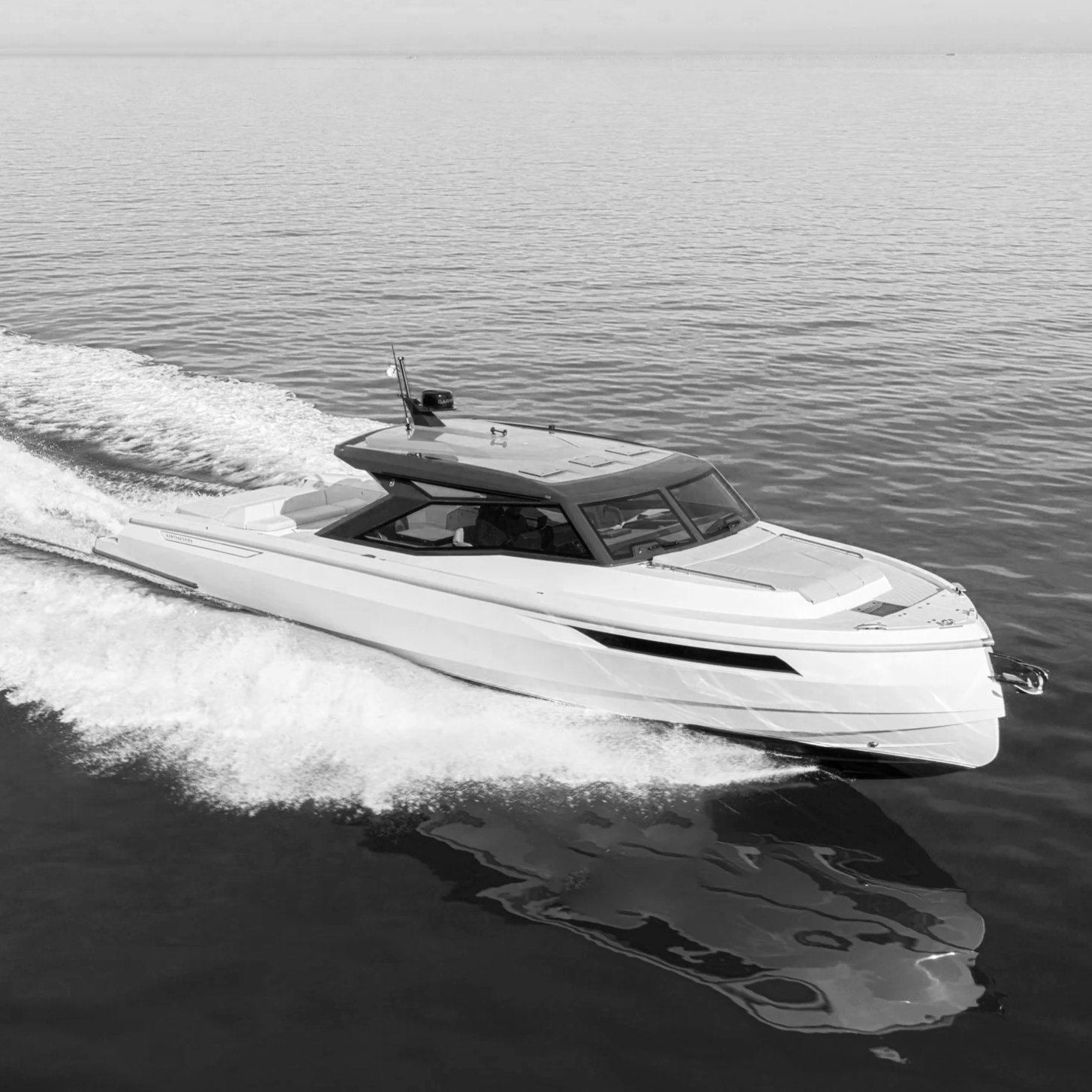 A motor yacht cruising on the water, creating a wake behind it.