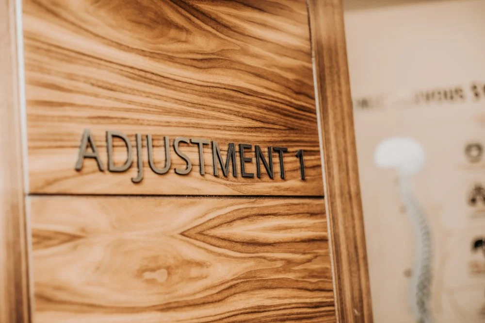 Wooden wall with the words 'Adjustment 1' in raised letters.