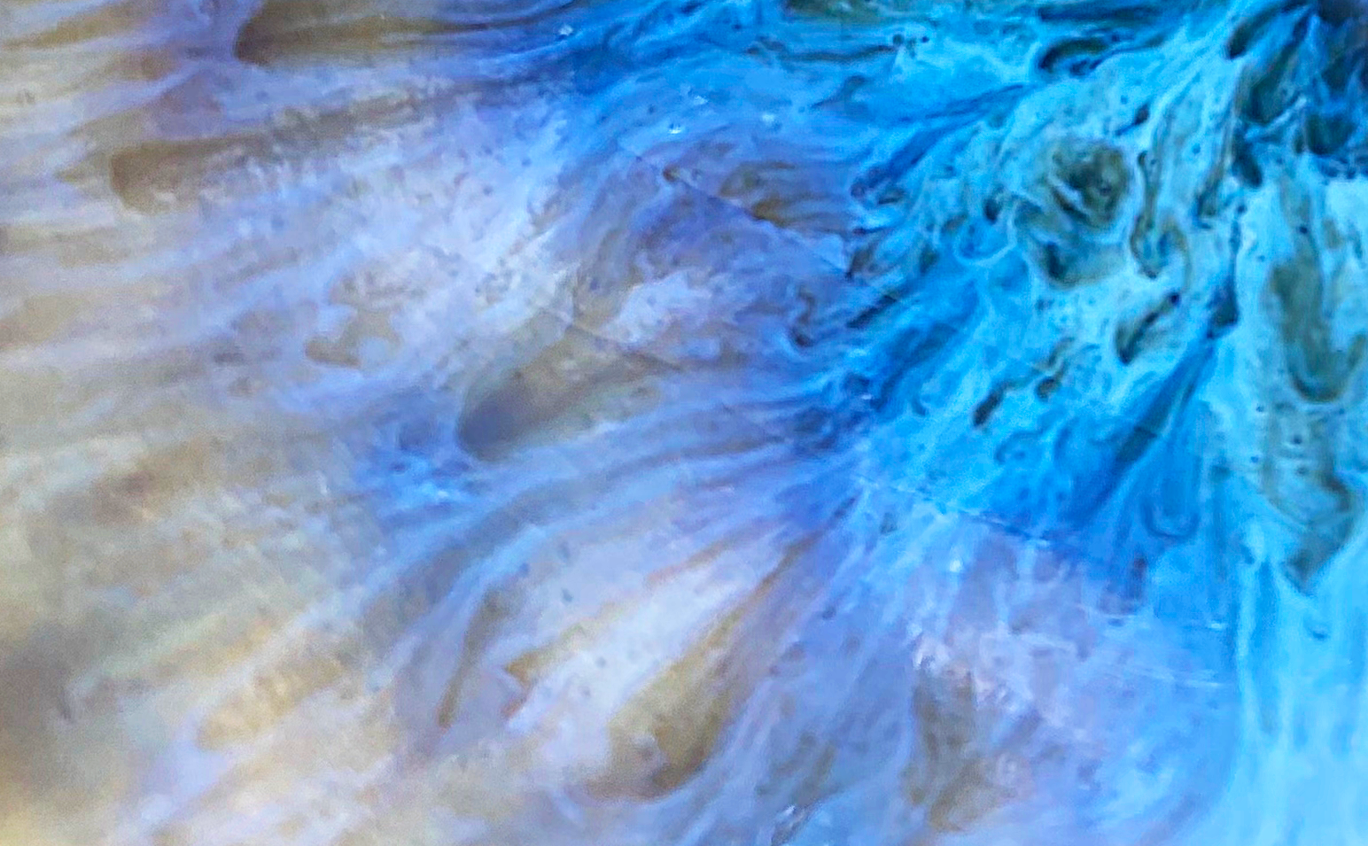 Close-up of swirling, blue and white marble-like abstract pattern with fluid, wave-like textures.