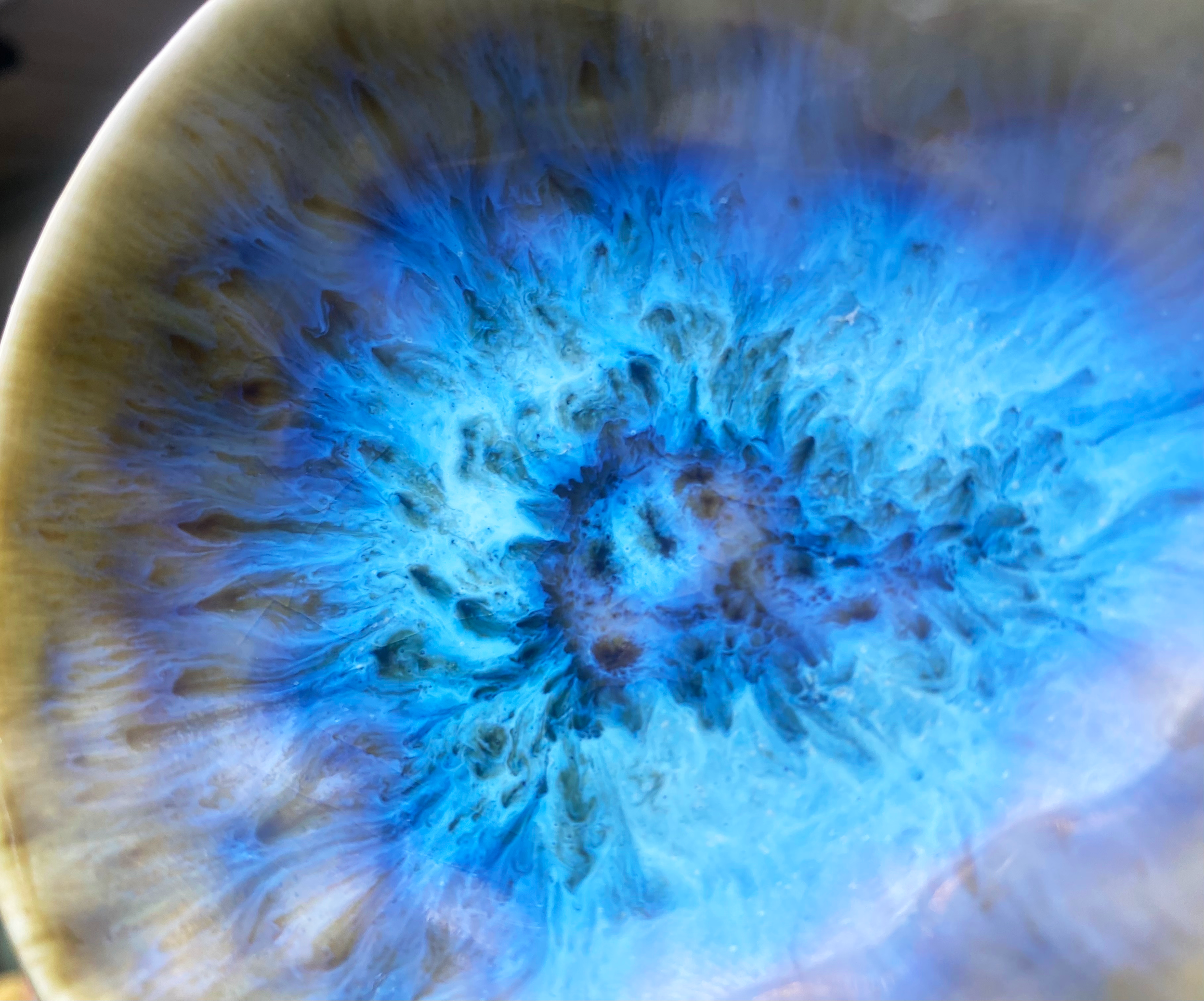 Close-up of blue ceramique with brownish swirling patterns and dark spots