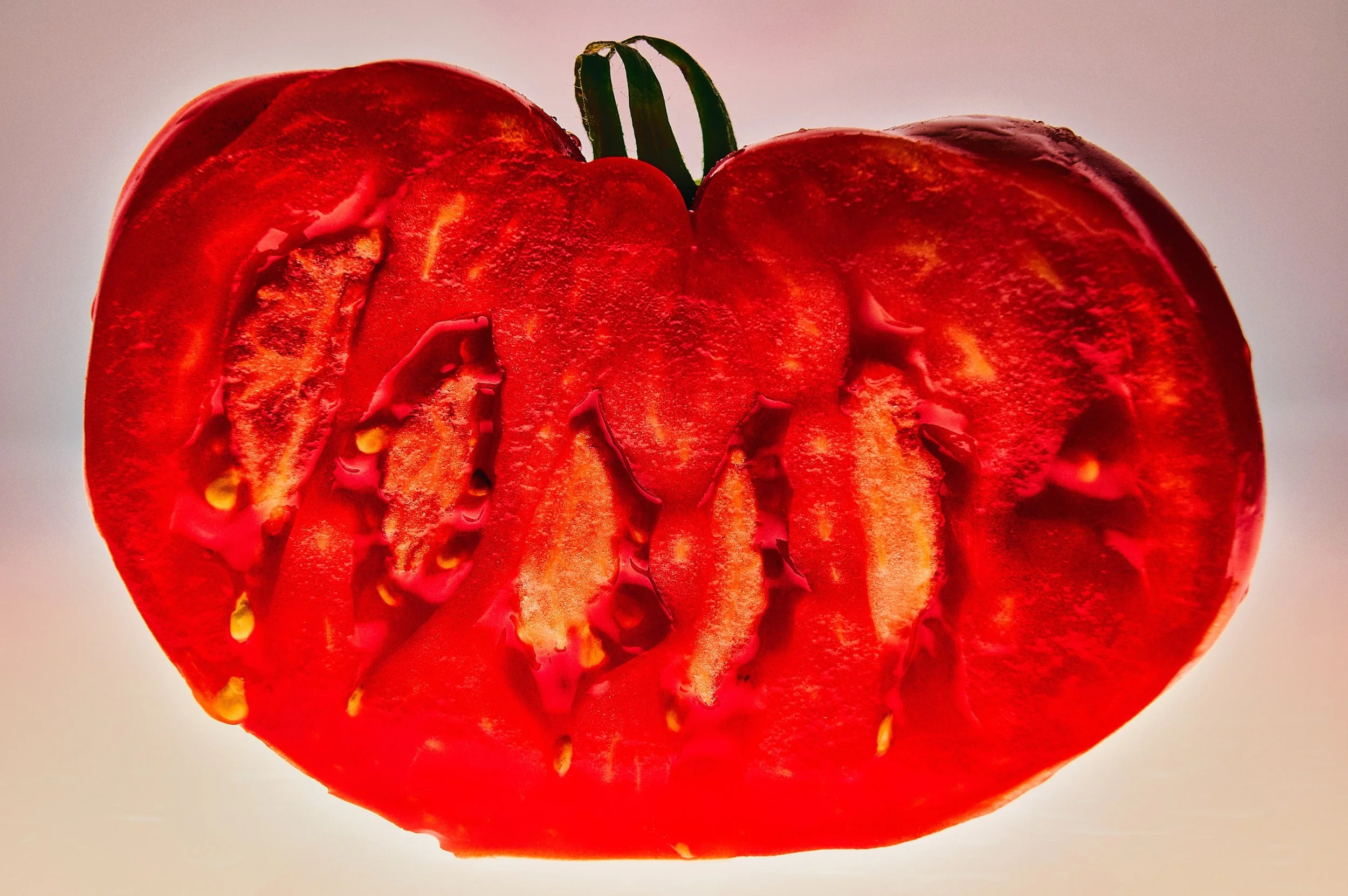 Close-up of a cross-section of a red bell pepper showing the inner seeds and flesh.