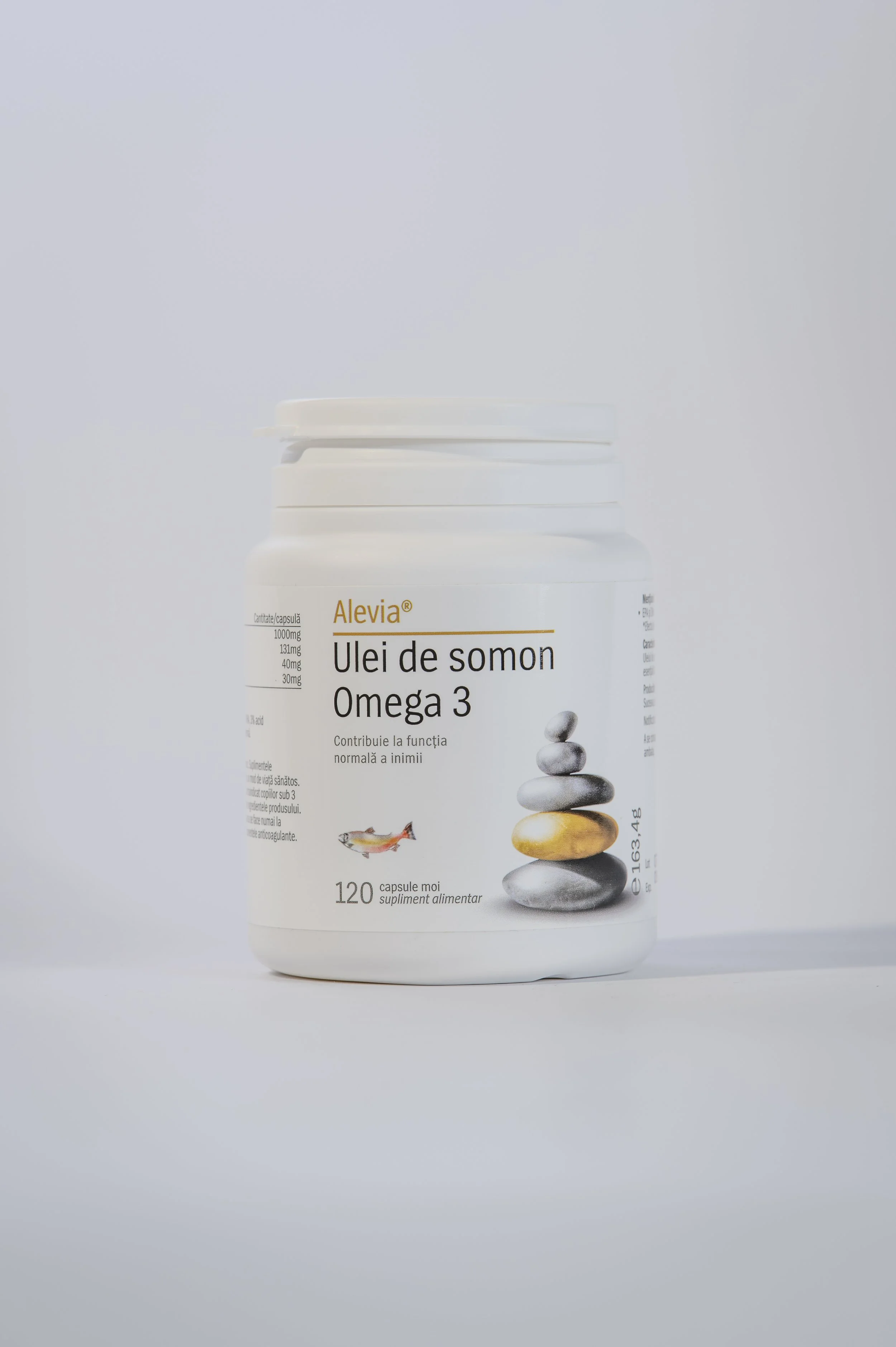 A white plastic bottle of Omega 3 fish oil capsules with a smooth, rounded lid, standing against a plain light background. The label has text in Romanian and features an image of stacked stones and a small fish.