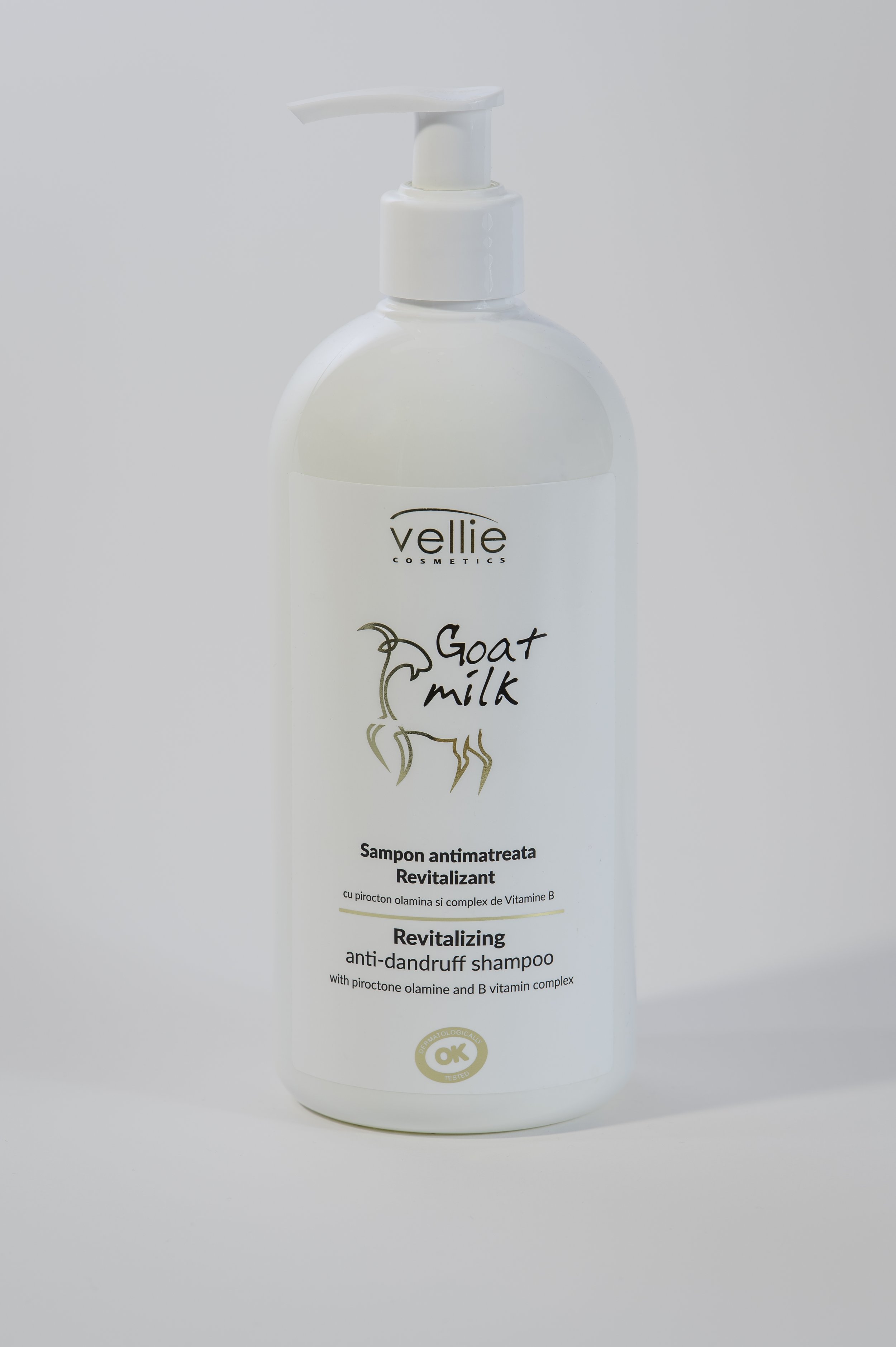A white bottle of Vellie Cosmetics Goat Milk revitalizing anti-dandruff shampoo with a pump dispenser and a label featuring a goat illustration and product description in both Romanian and English.