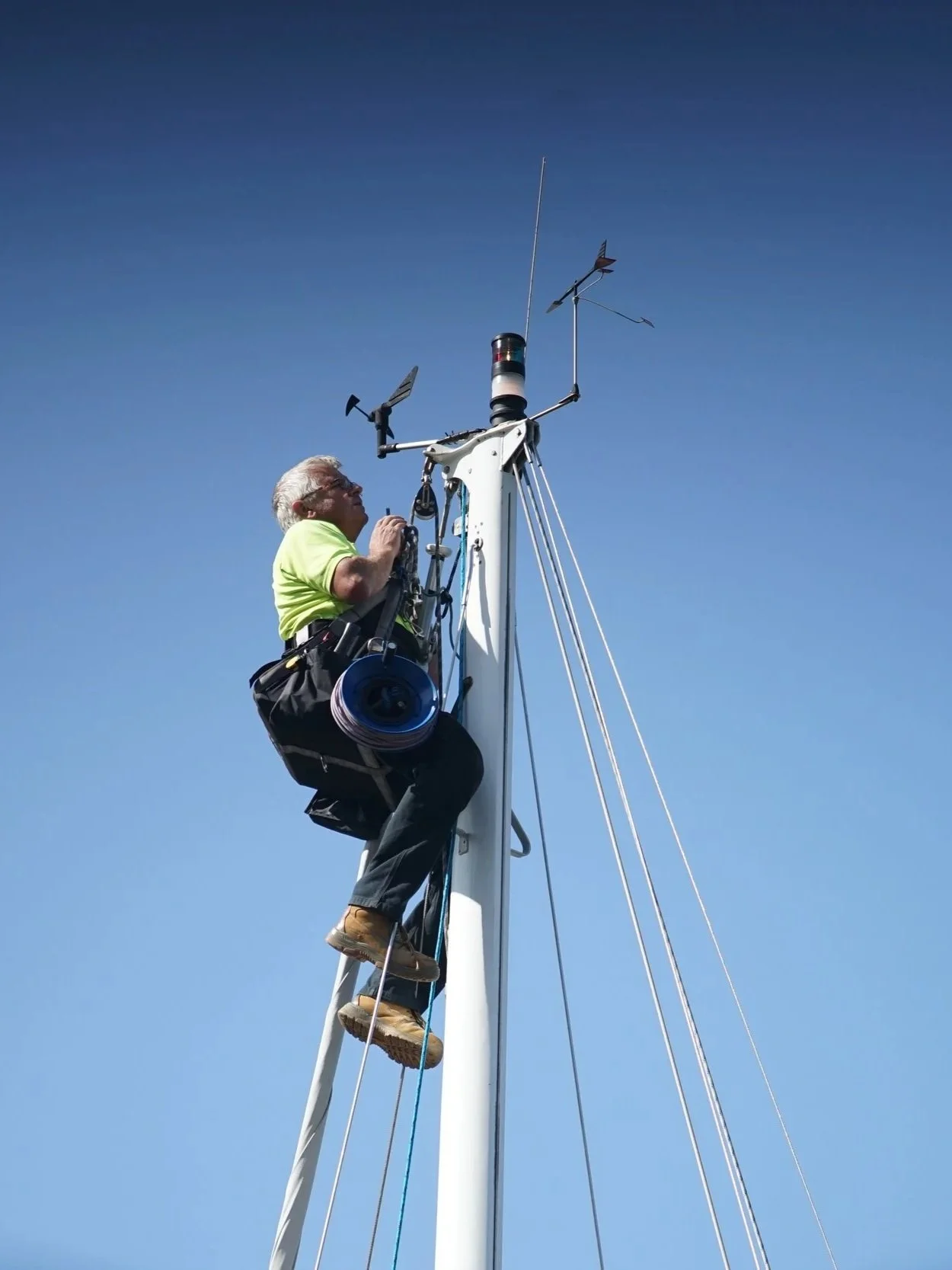 Marine rigger working on a yacht mast during rigging inspection and furling system installation.