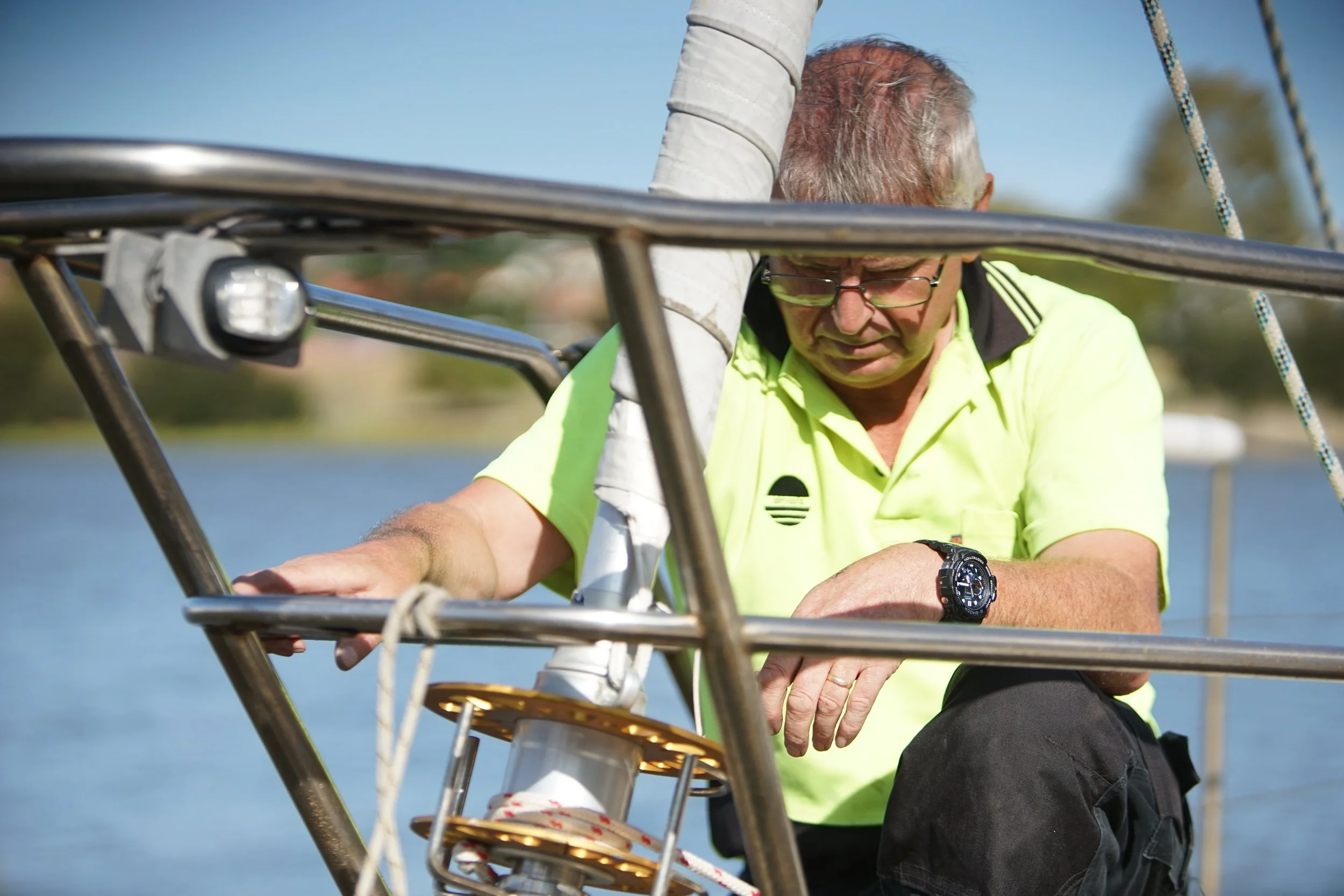 Marine rigger inspecting and adjusting yacht rigging during a furling system installation.