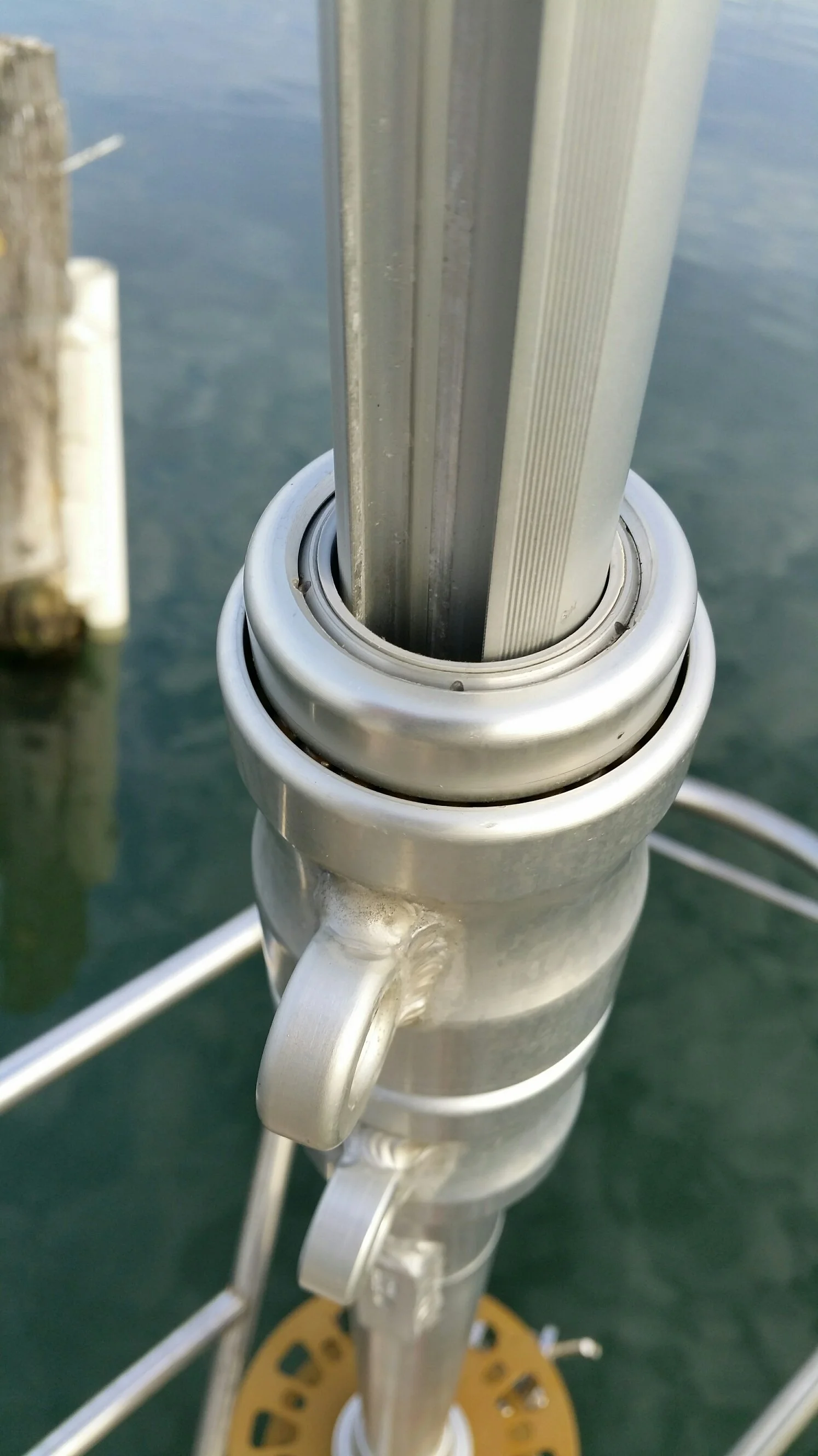 Close-up view of a metal railing post on a boat dock with water in the background.