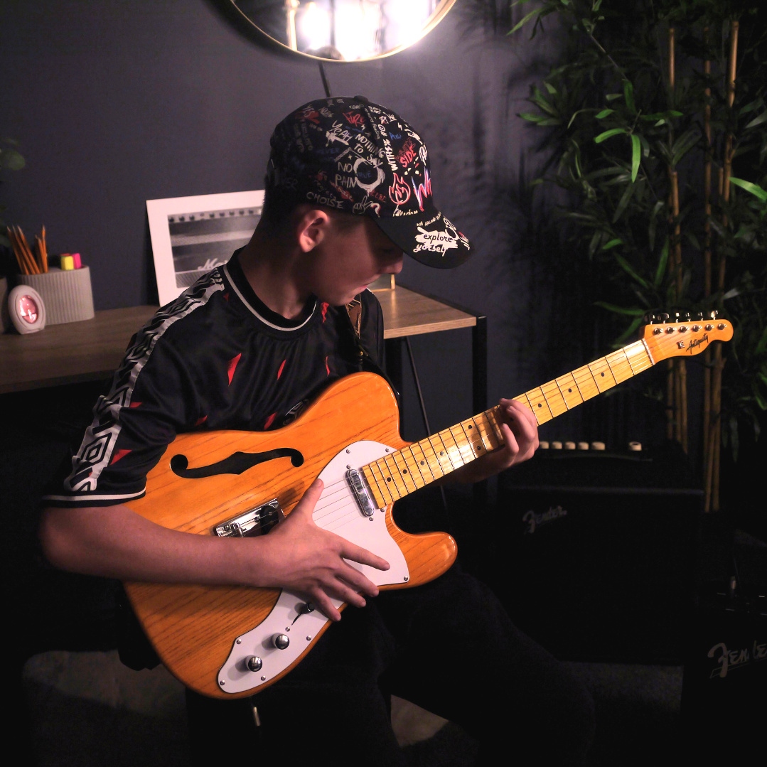 Social media content clip of a boy playing guitar, taken from a showcase video for a local music tuition business.