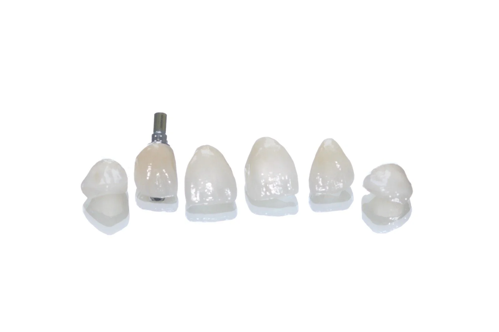Set of dental crowns and abutment on a white background.