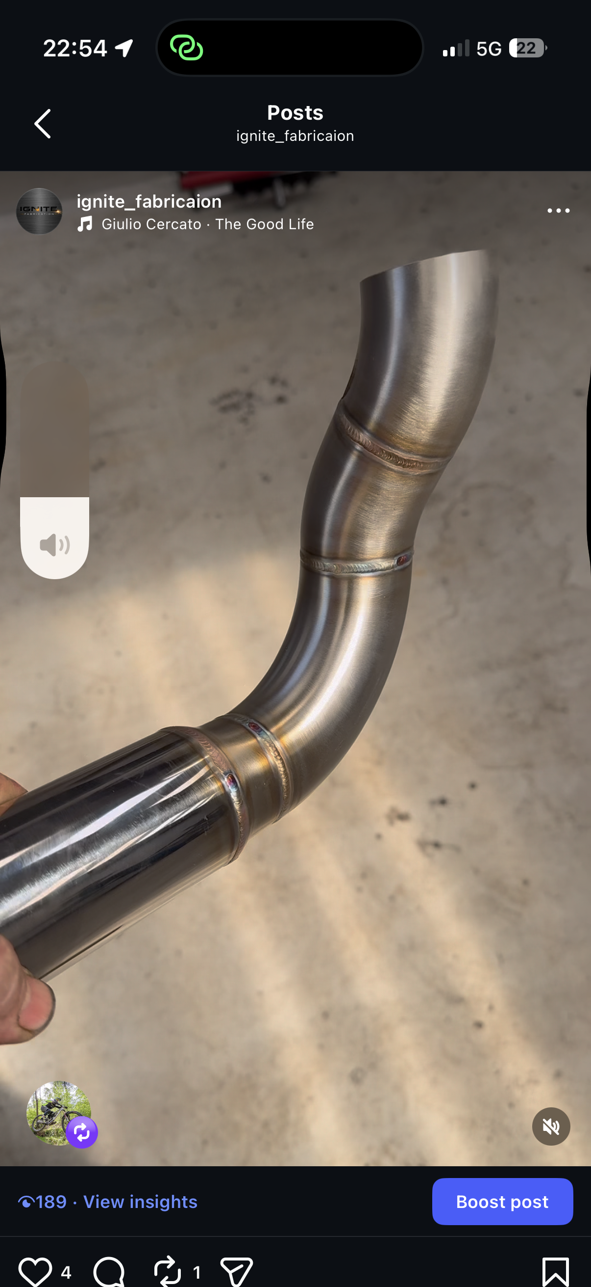 Close-up of a metallic pipe with welded joints, held in a person's hand.