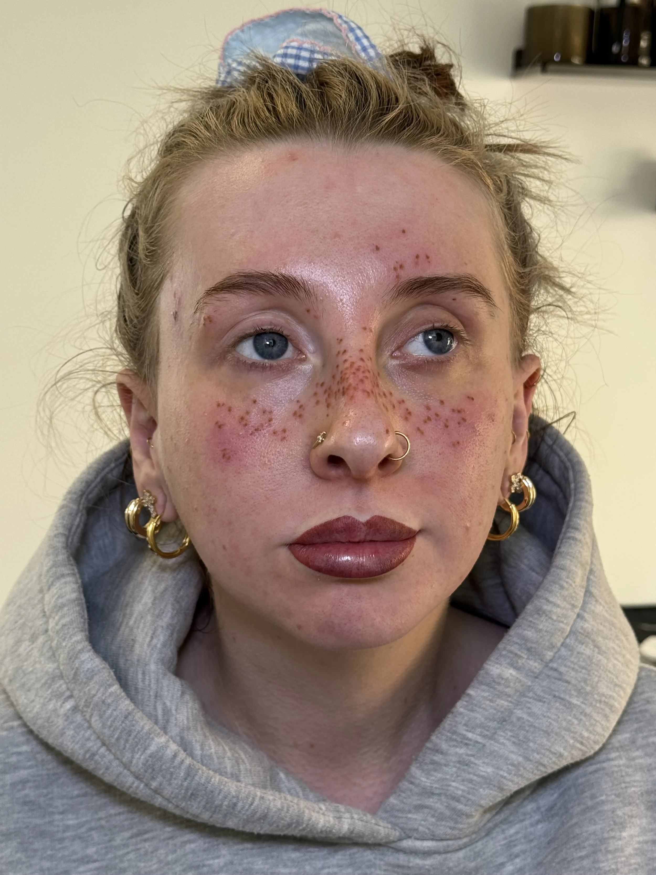 Close-up photo of a young woman with fresh pmu ombre lip blush and faux freckle tattoos