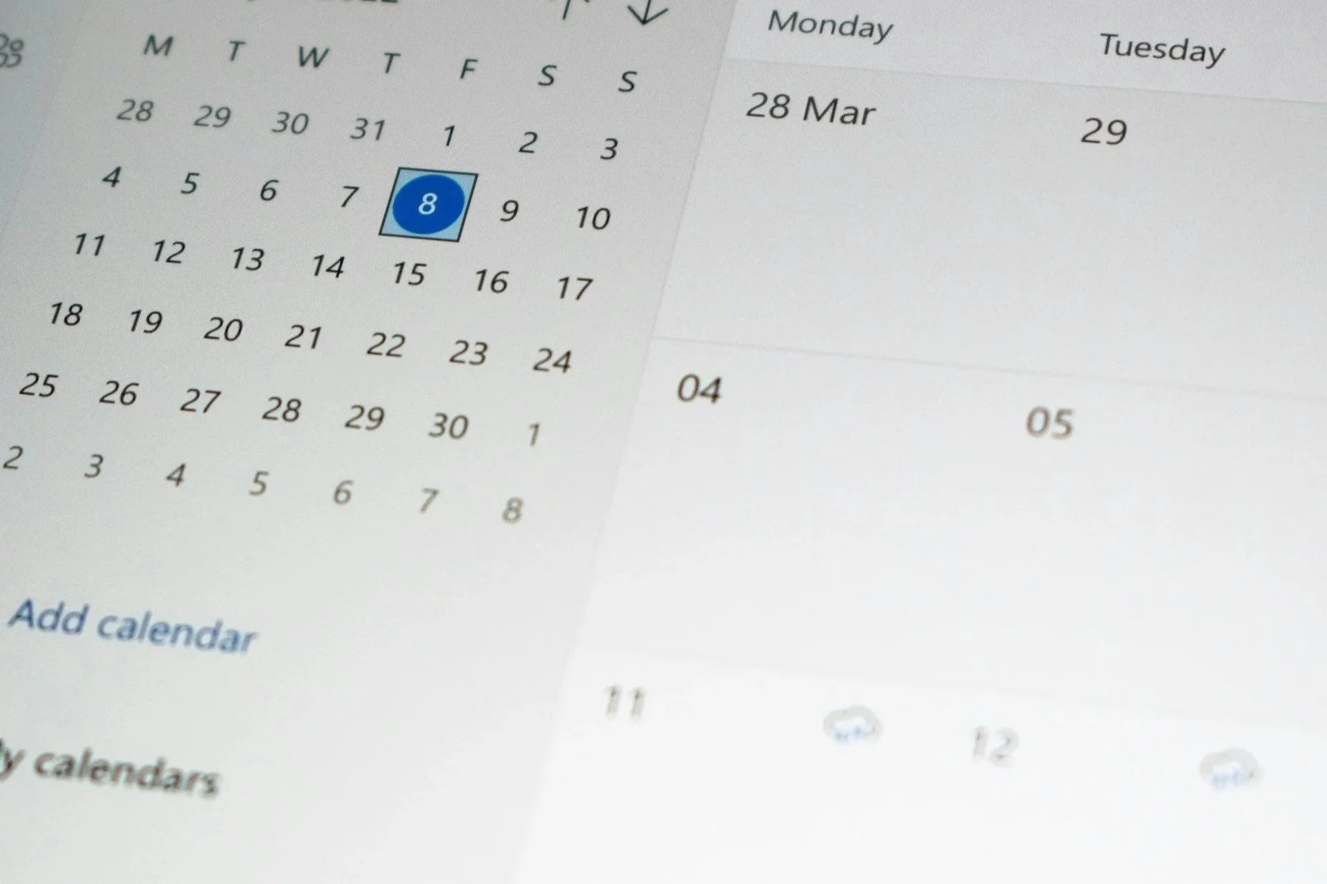 Close-up of a digital calendar displaying March 28th with a blue circle and number 8 on it, indicating a date, with parts of the month and week visible.