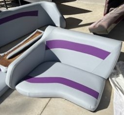 A white and purple lounge chair with a curved design on an outdoor surface.