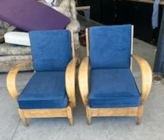 Pair of blue velvet chairs with wooden armrests and legs.
