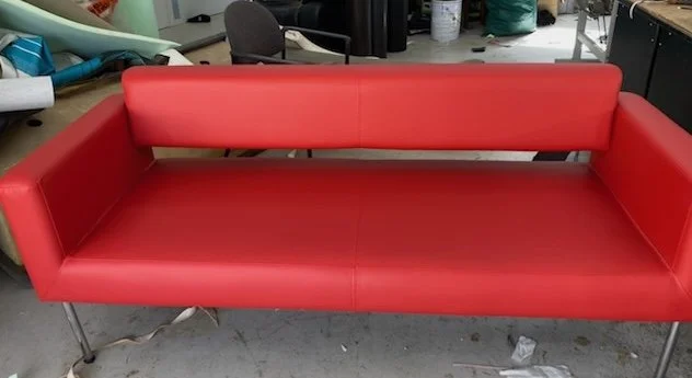 Red modern sofa in a workshop or storage space