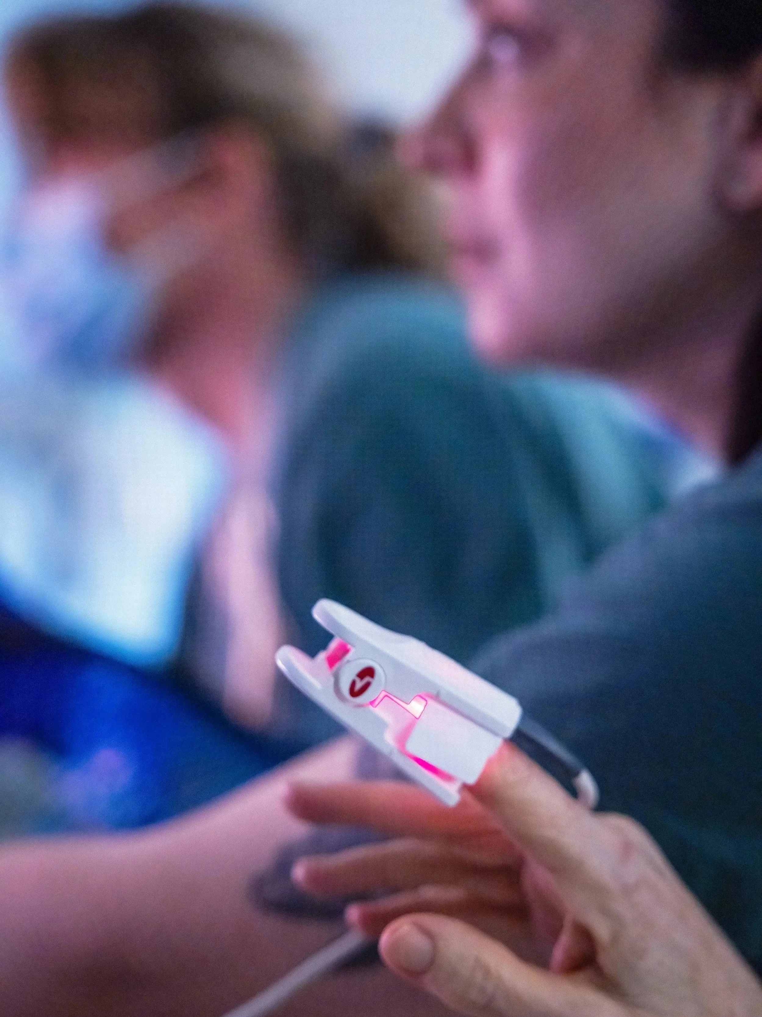 Pulse monitor for patient with healthcare staff in background