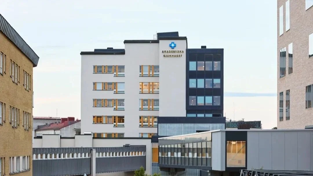 Exterior view of a modern hospital building with the sign 'Akademiska Sjukhuset' on the front.
