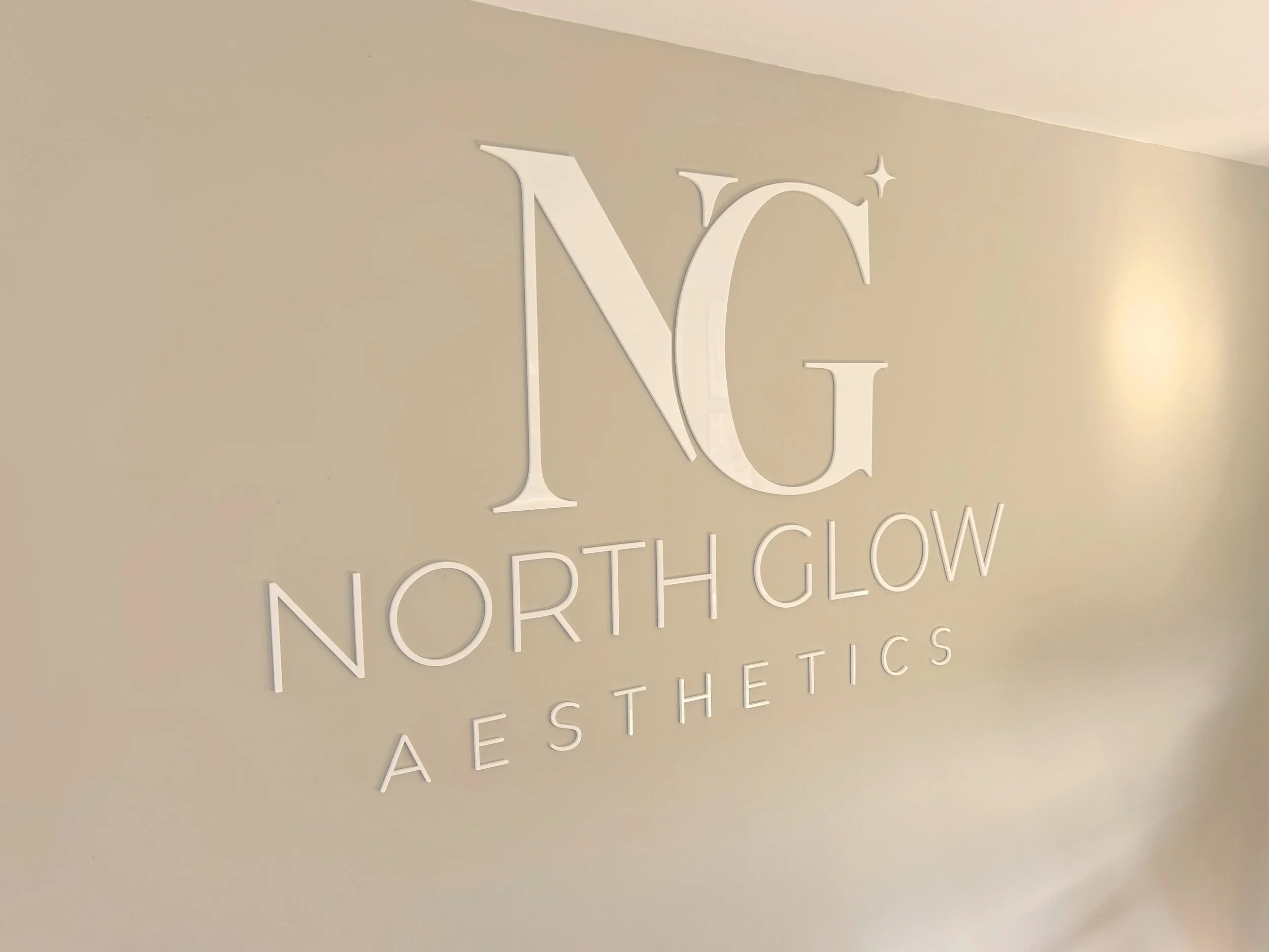 Close-up of the North Glow Aesthetics wall logo, Norden, Rochdale.