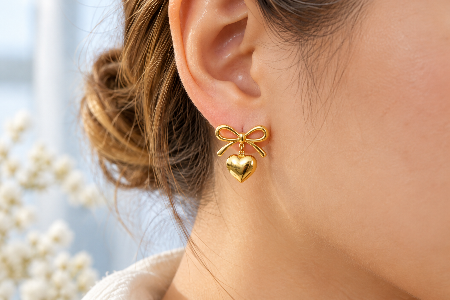 Gold Bow and Heart Earring Close-Up.png