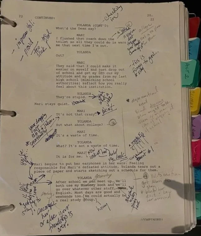 Page from a script or notebook with handwritten notes and annotations. Contains dialogue between characters Yolanda and Mari, with extra comments, questions, and reminders written around the text.