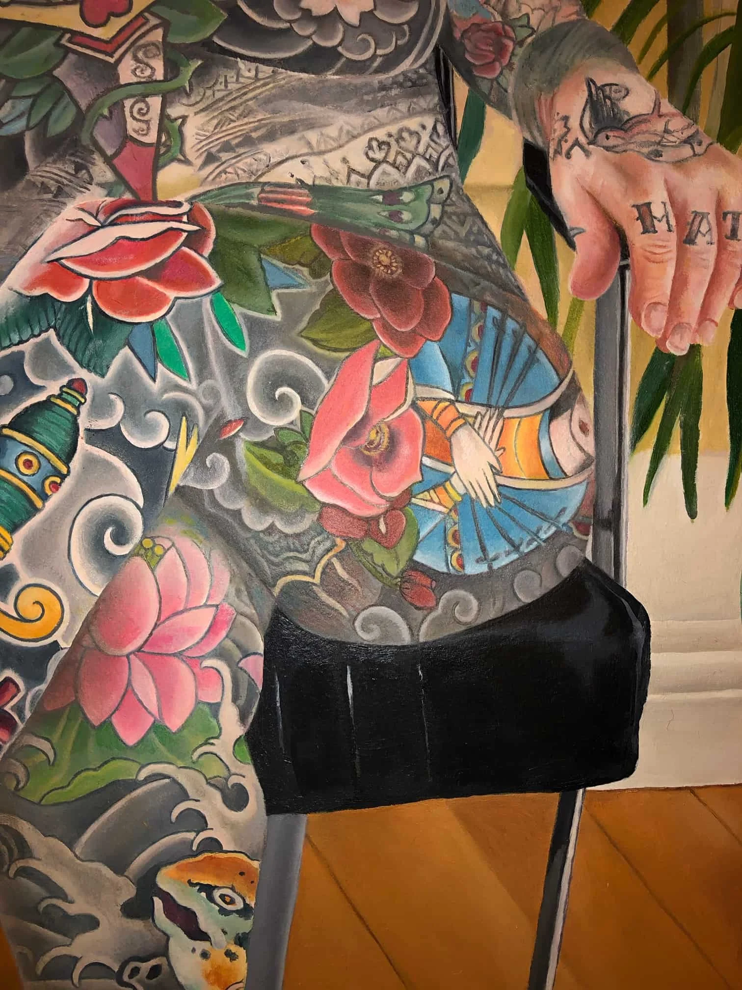 Close-up of a female body ornate with tattoos,  seated on a chair with wooden floor background