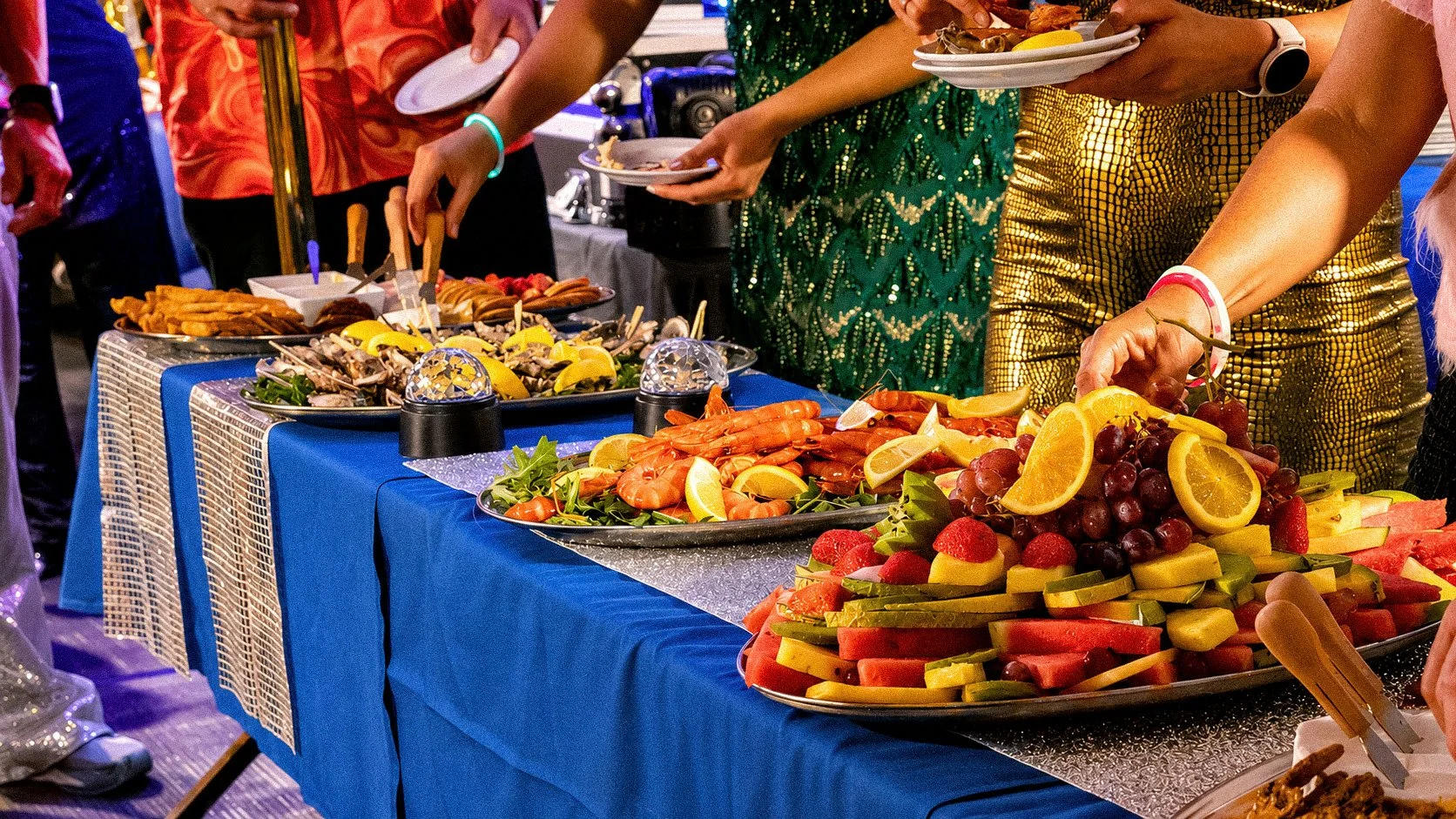 Buffet table with various fresh fruits, seafood, and appetizers at a party or event.