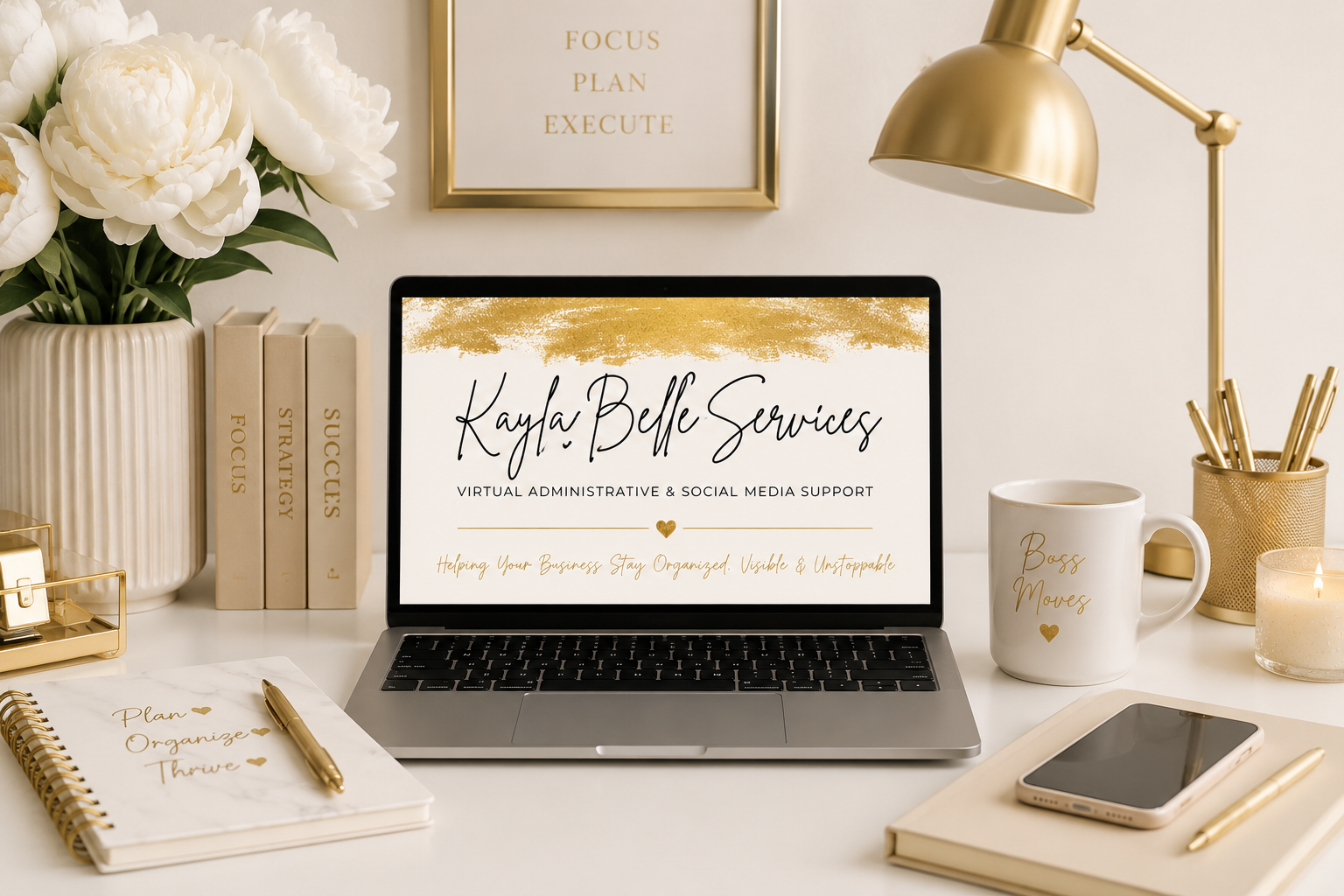 A desk setup with a laptop displaying 'Kayla Belle Services: Virtual Administrative & Social Media Support'. The desk has a notebook, gold pen, coffee mug labeled 'Boss Moves', smartphone, a gold pen holder, a lit candle, and a vase with white flowers. A framed print on the wall says 'Focus, Plan, Execute'.