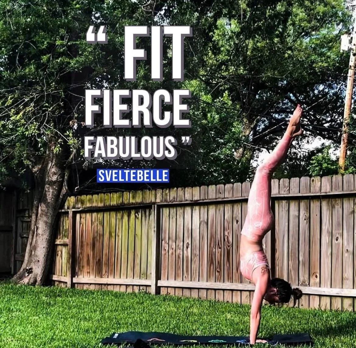 Woman in pink outfit doing handstand on a yoga mat in a backyard with the words "Fit Fierce Fabulous" above, surrounded by trees and a wooden fence.