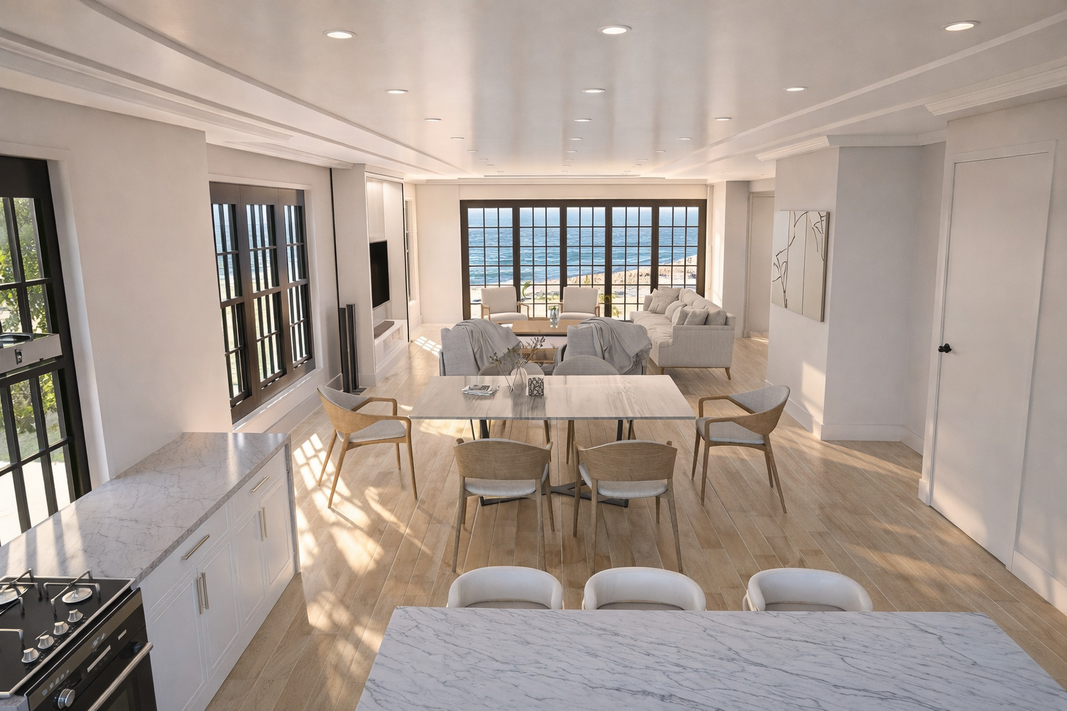 An open-concept living and dining area with white walls, large windows showing the ocean view, a marble kitchen island, a dining table with chairs, and a seating area with sofas and armchairs facing large windows.