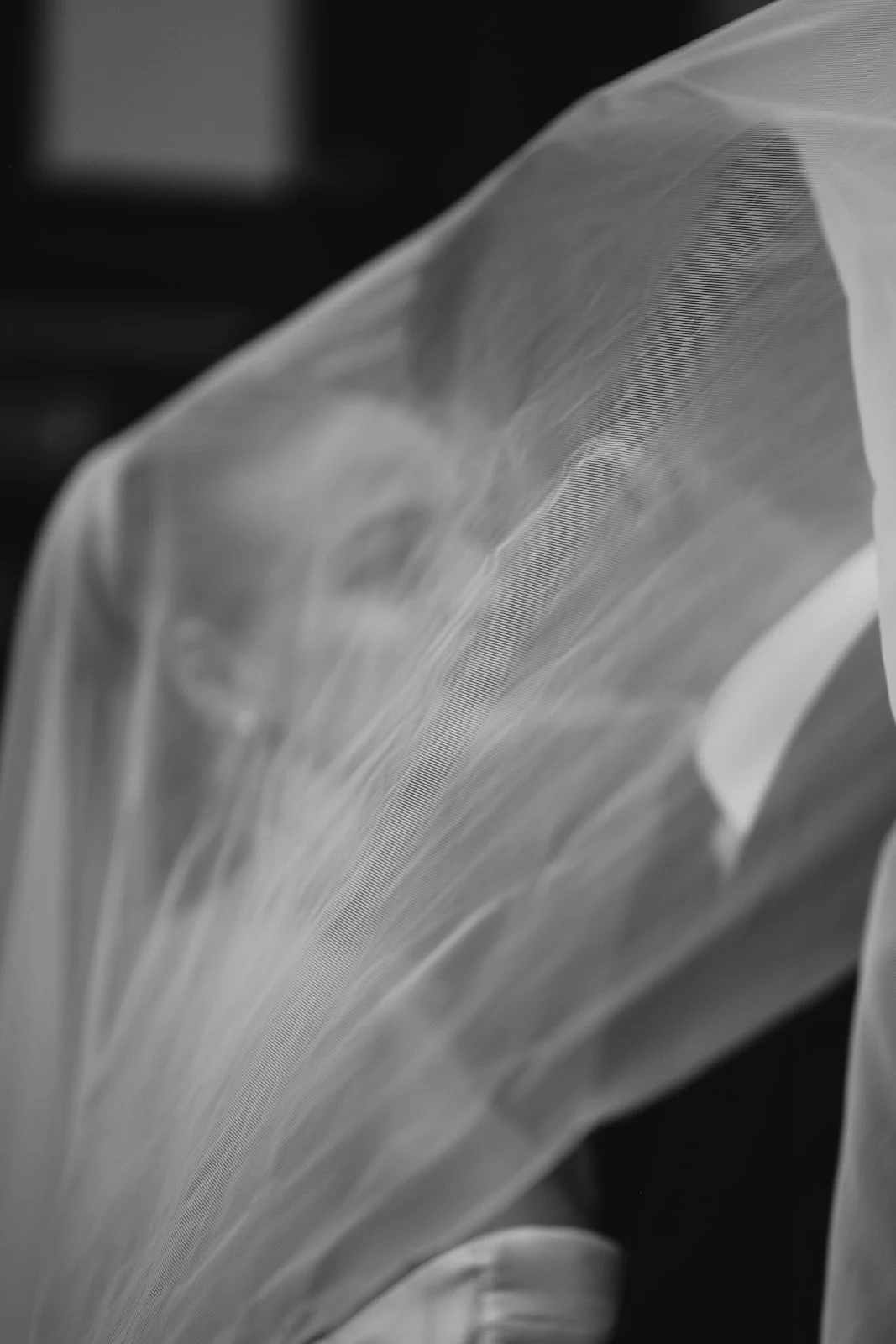 Close-up of a delicate, semi-transparent fabric with fine texture, draped in soft folds.