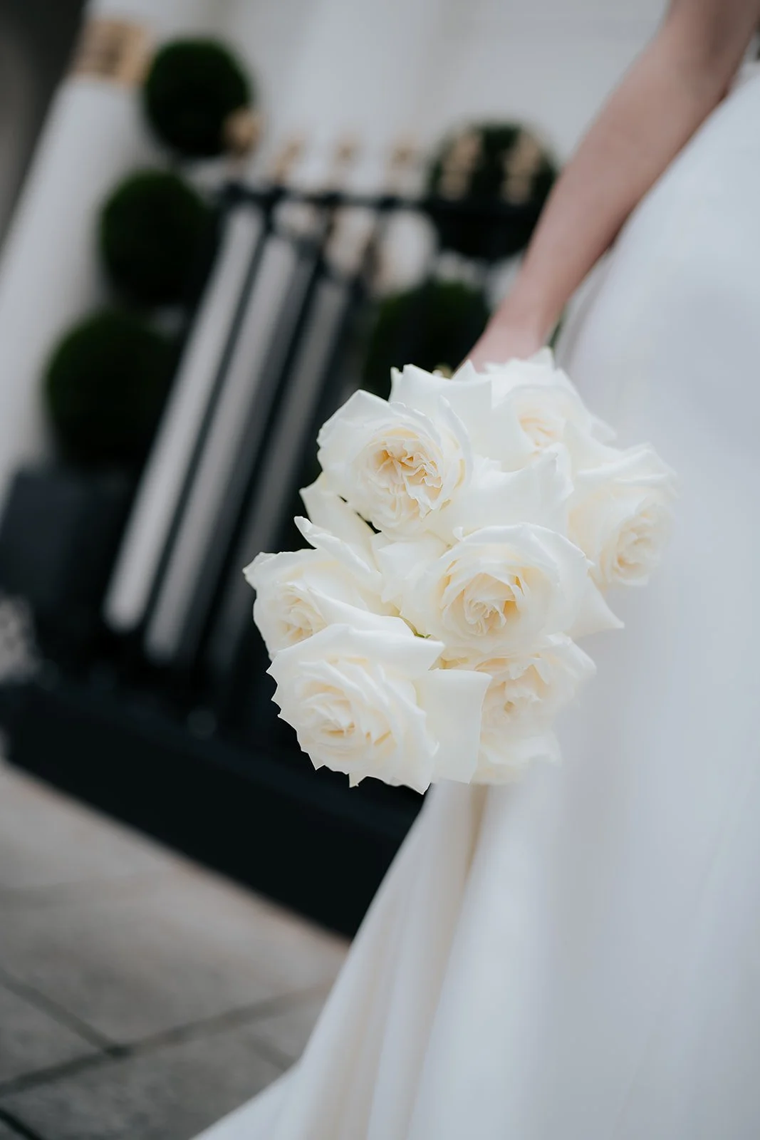 A bride holding a bouquet of white roses during a wedding.
