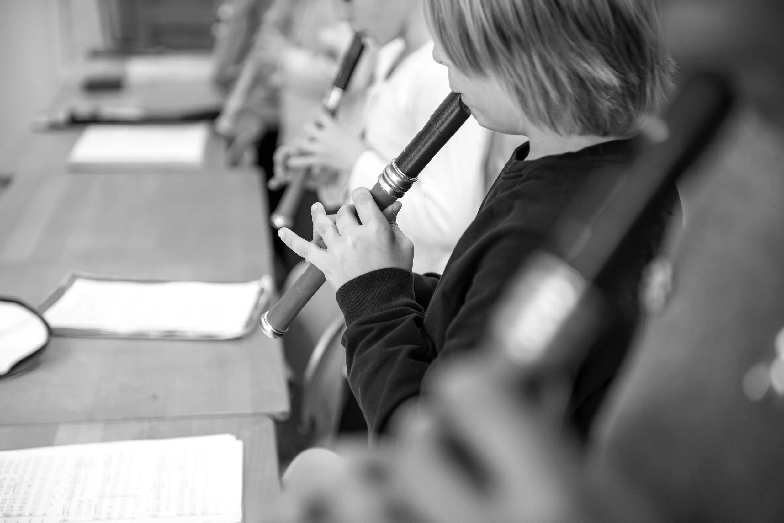 Kinder sitzen in einer Reihe und schauen durch Mikros, wahrscheinlich im Unterricht oder bei einem Wissenschaftsproject.