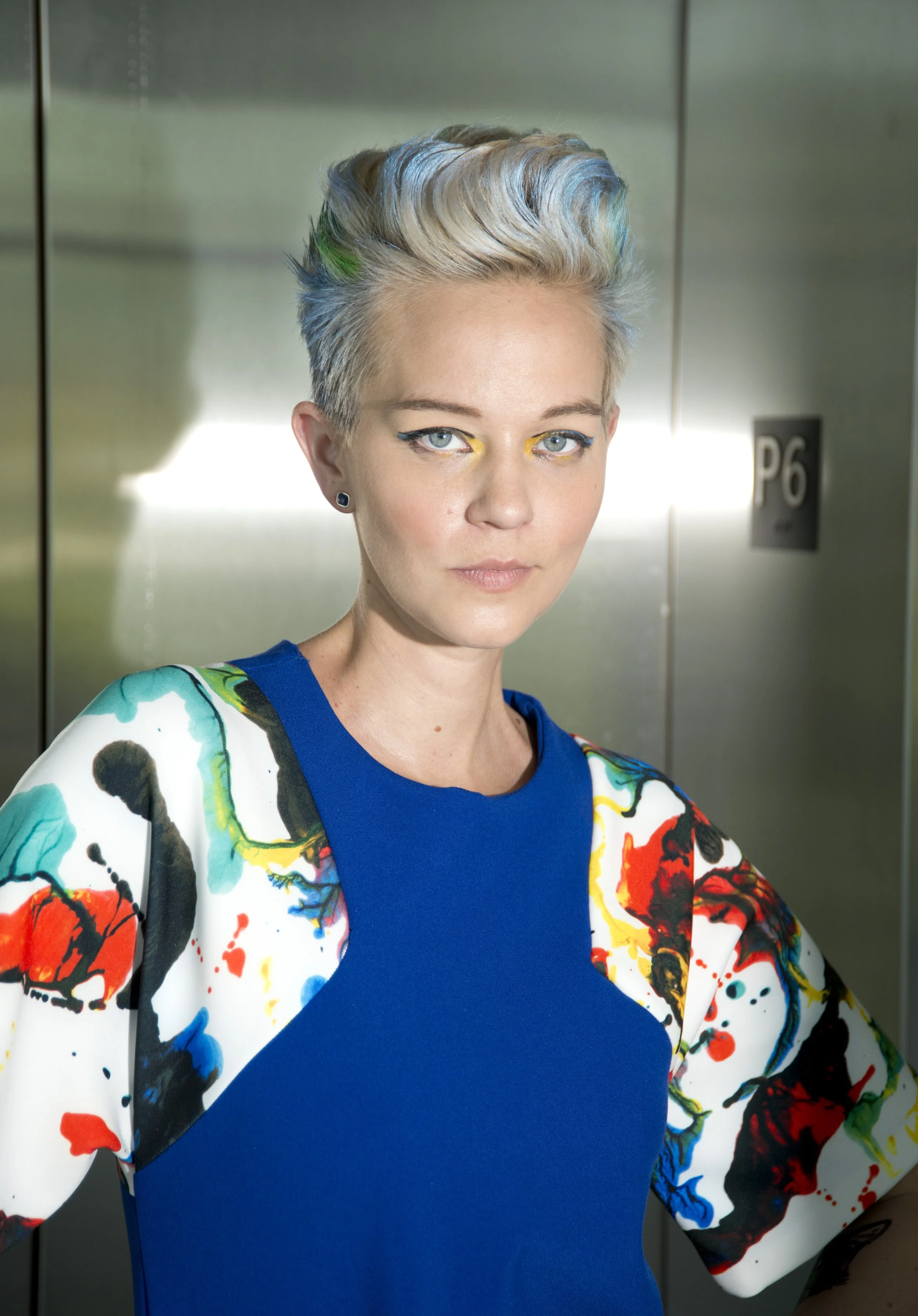 The theorem collection uses designer end bolts. Dress with paint splatter print on geometric raglan sleeves and pockets. scuba knit and blue tricot knit on body-Detail of sleeves and neckline.