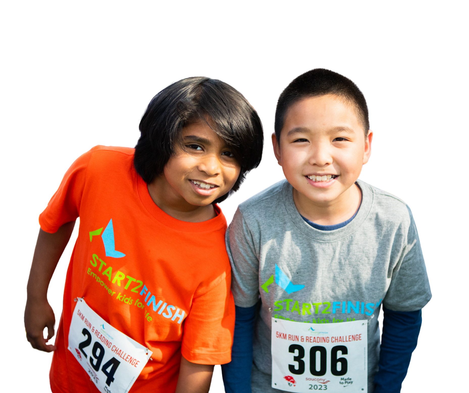 Two children smiling at a charity run event, wearing race bibs and event T-shirts that read 'START2FINISH,' with one child wearing an orange shirt and the other a gray shirt.