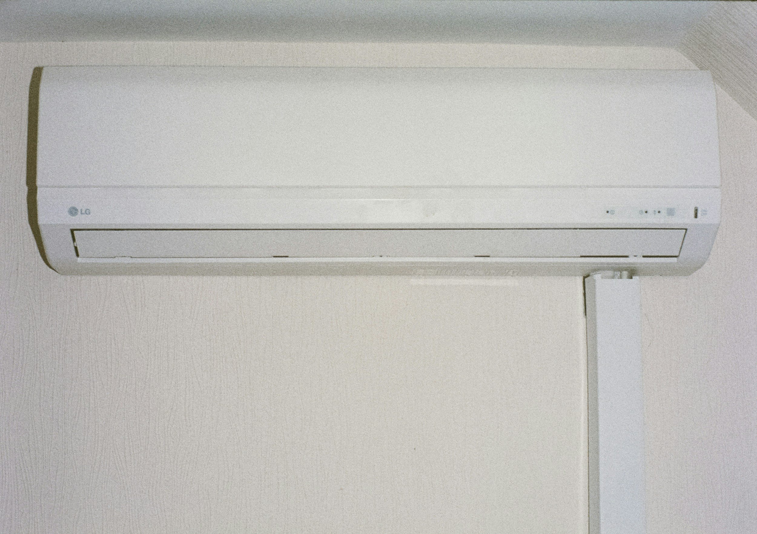 Wall-mounted LG air conditioner unit on a white wall.