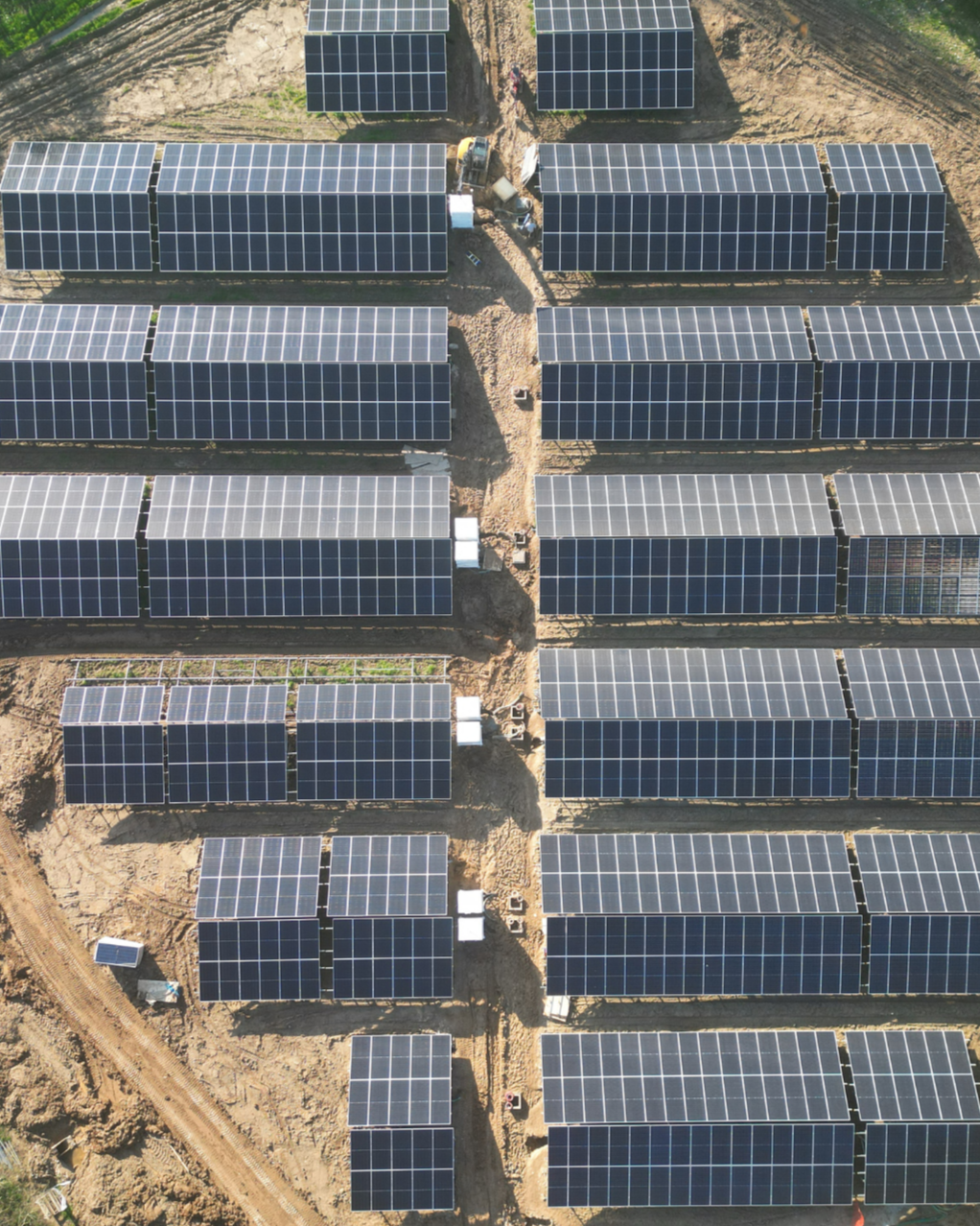 Aerial view of multiple rows of solar panels installed on a construction site.