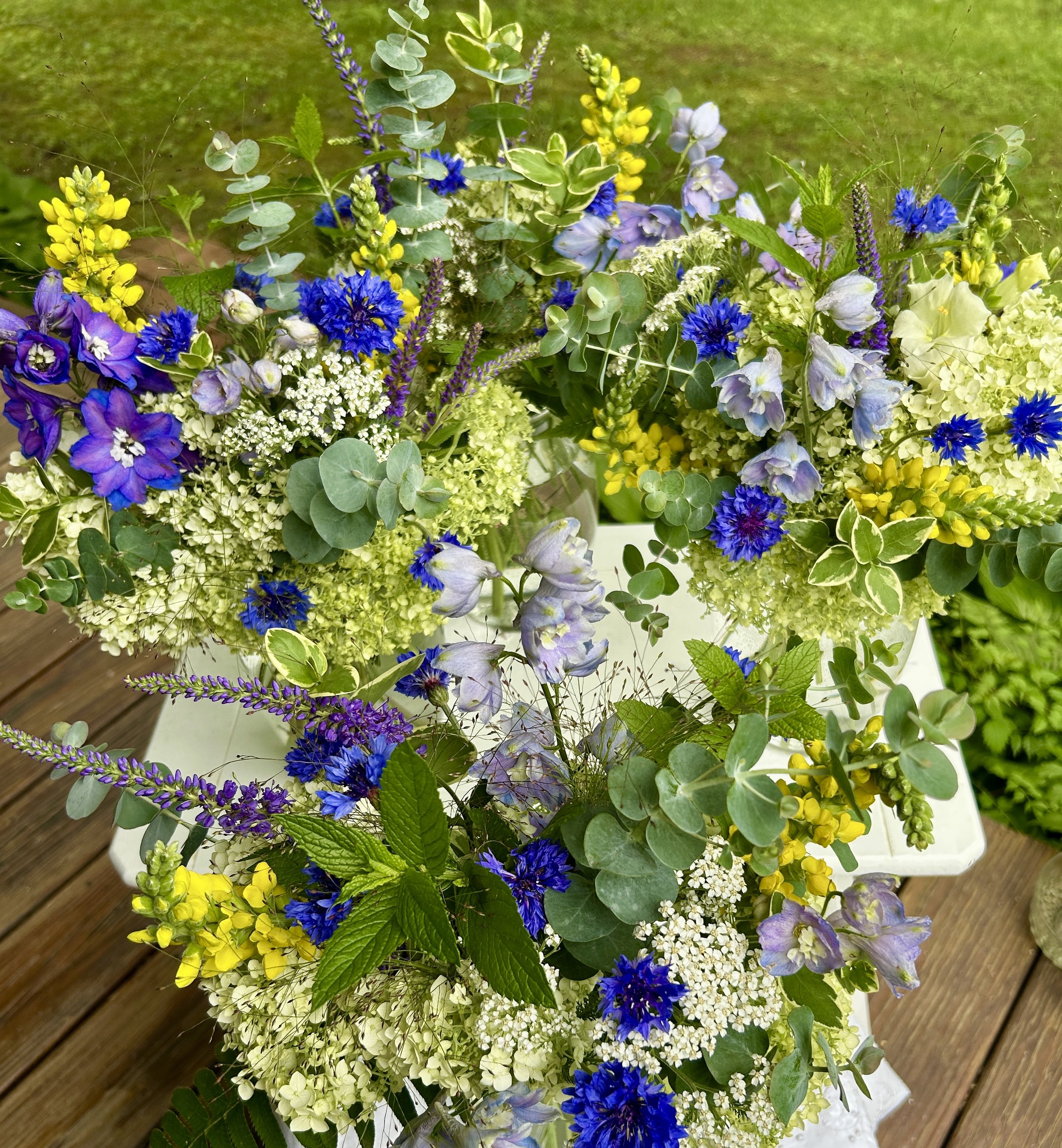 A bouquet of various colorful flowers on a wooden surface.