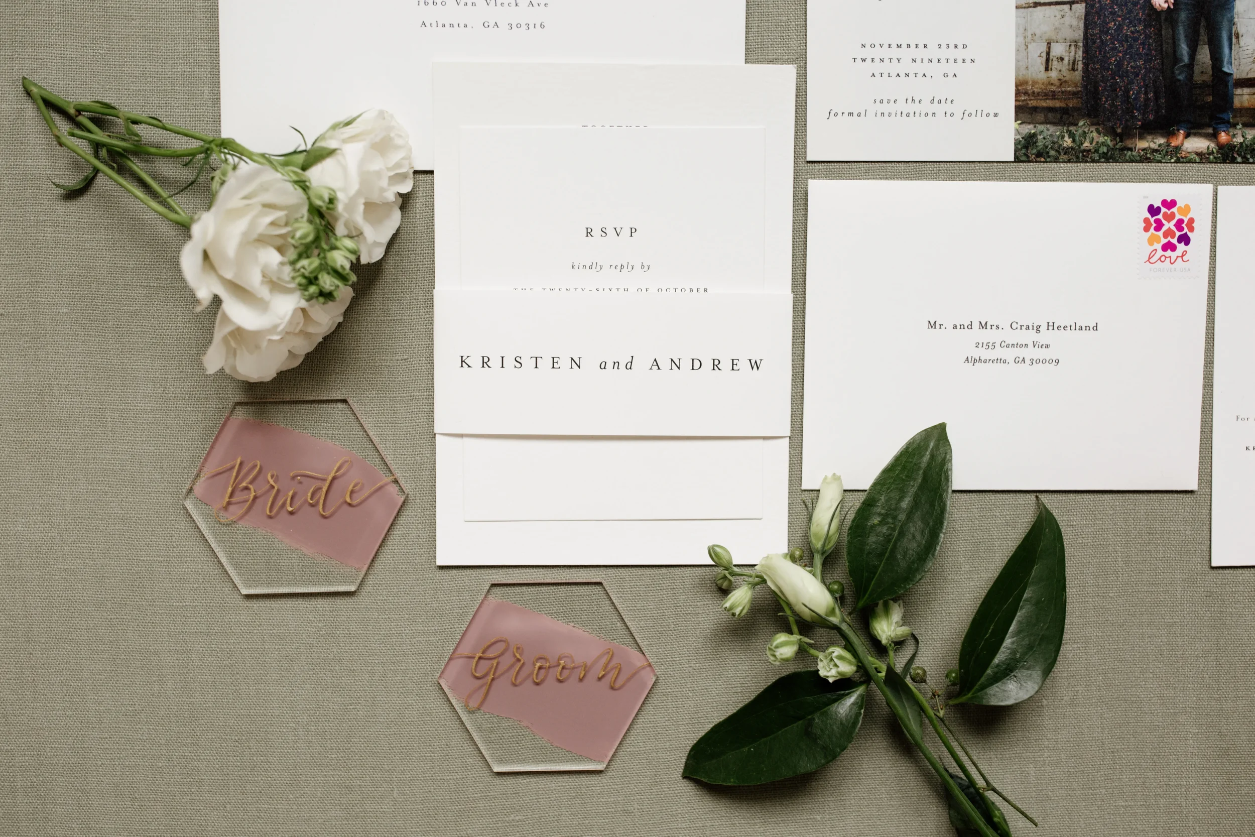 Painted back acrylic hexagon bride and groom place card with gold script calligraphy.