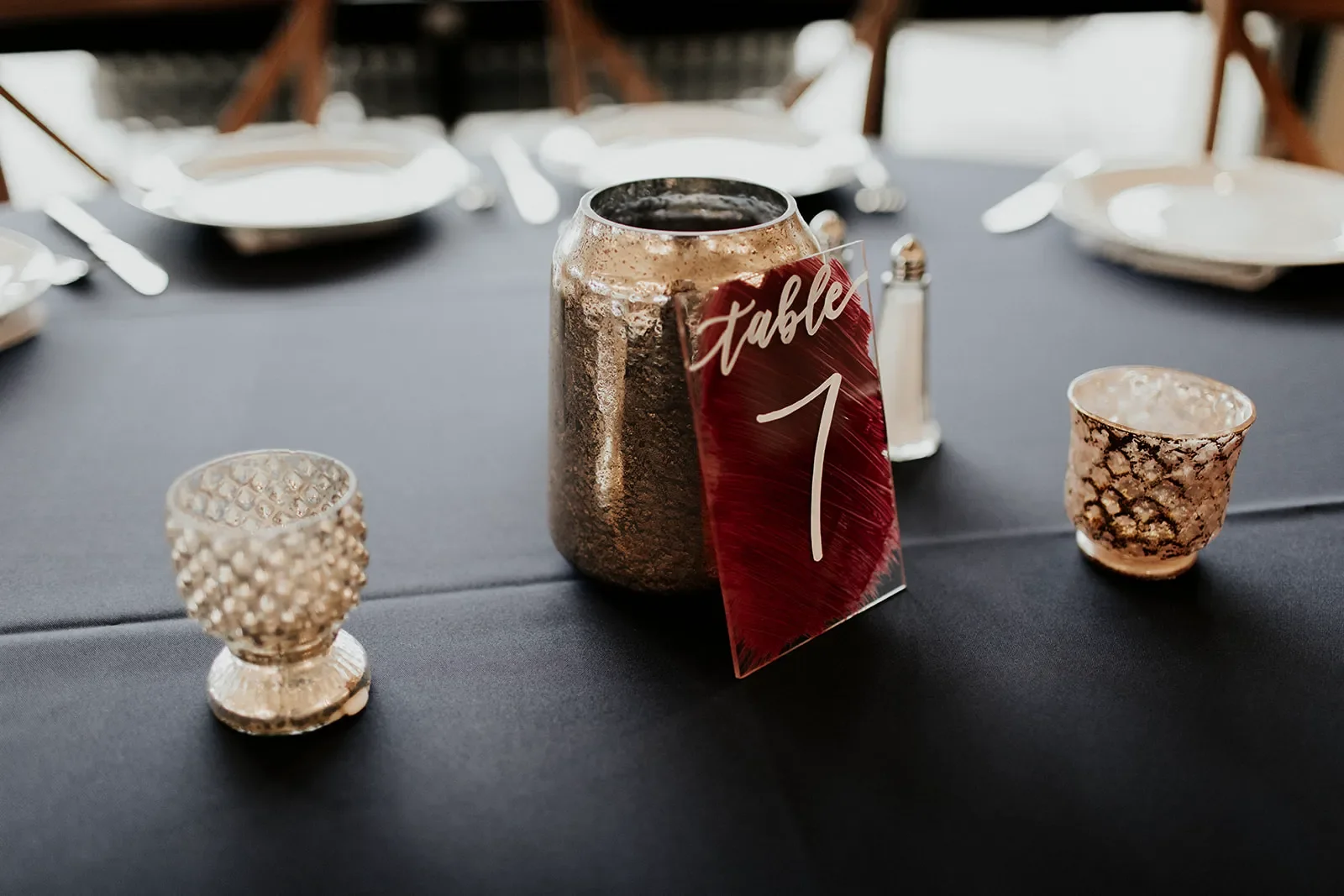 Burgundy painted-back acrylic table number 7 with white hand-lettering for a moody autumn wedding.