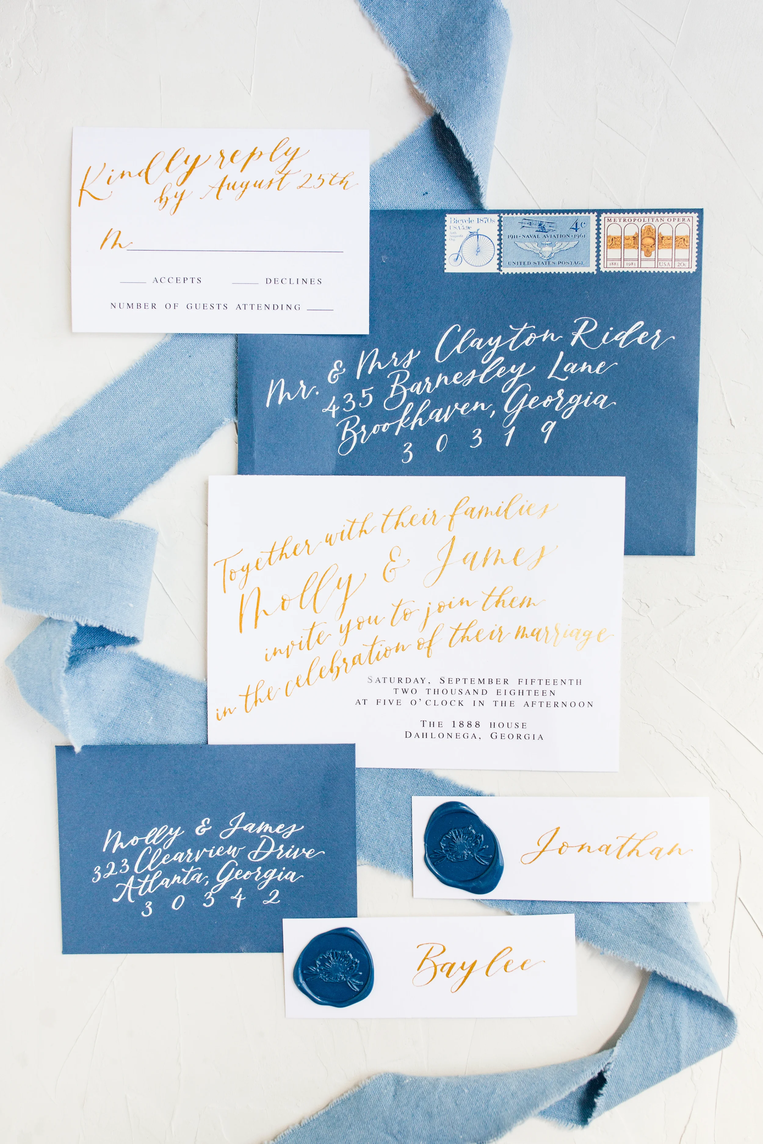 Fine art stationery suite featuring dark blue calligraphed envelopes and blue wax seal place cards.