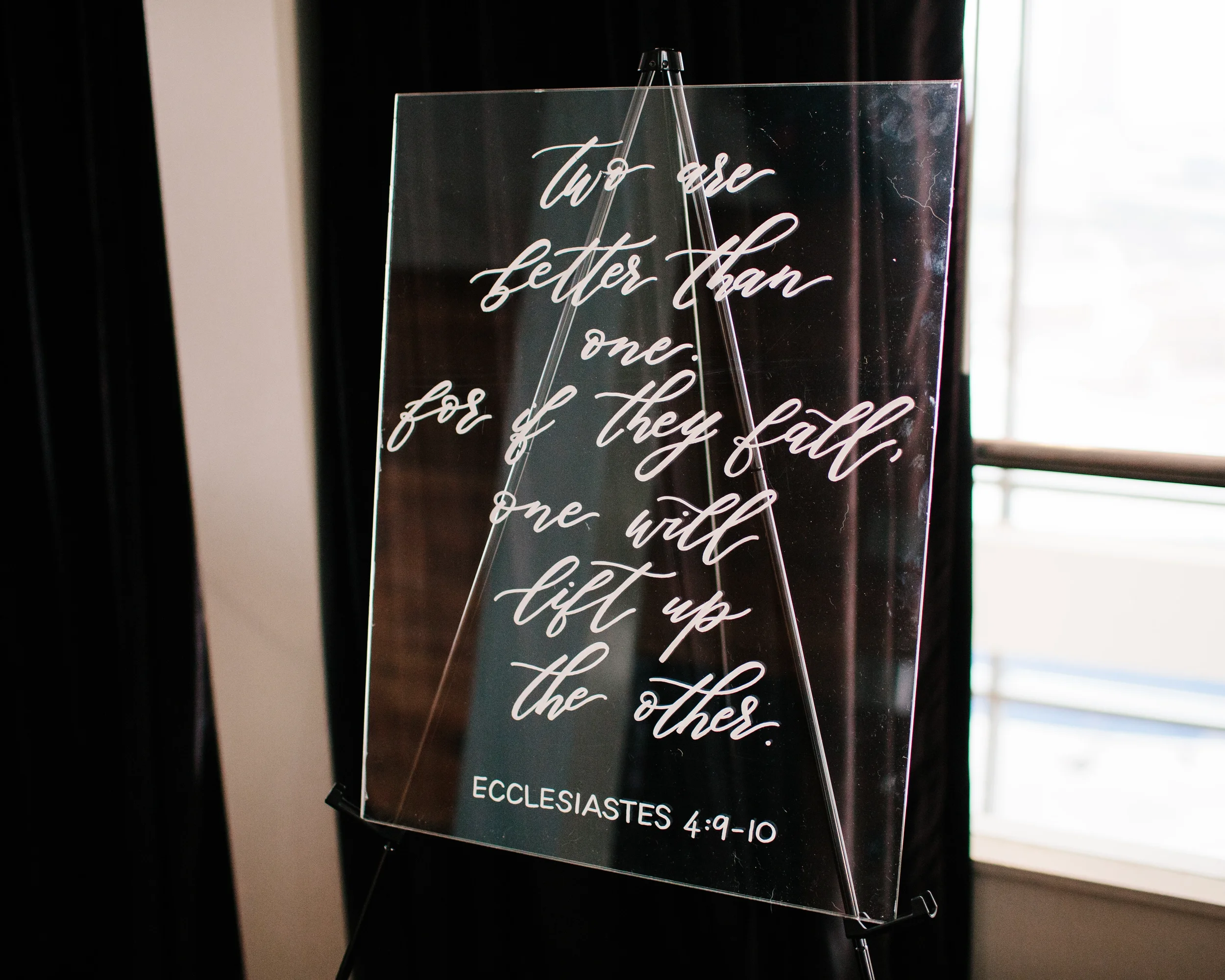 Elegant script calligraphy wedding verse hand-lettered on a clear acrylic sign.
