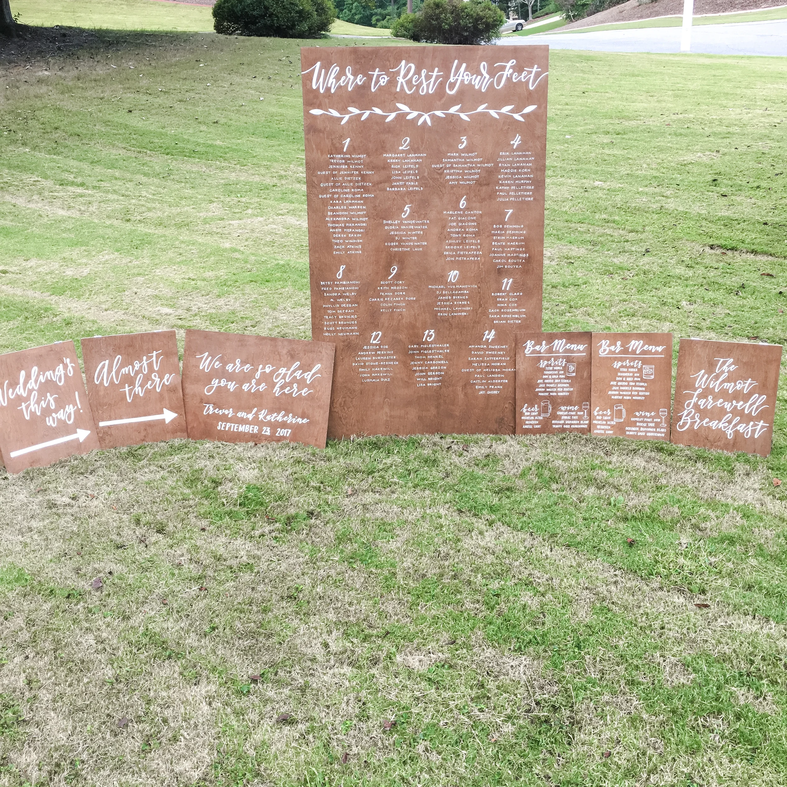Stained wood wedding seating chart. bar menu, welcome sign, and a-frame directional board signs.
