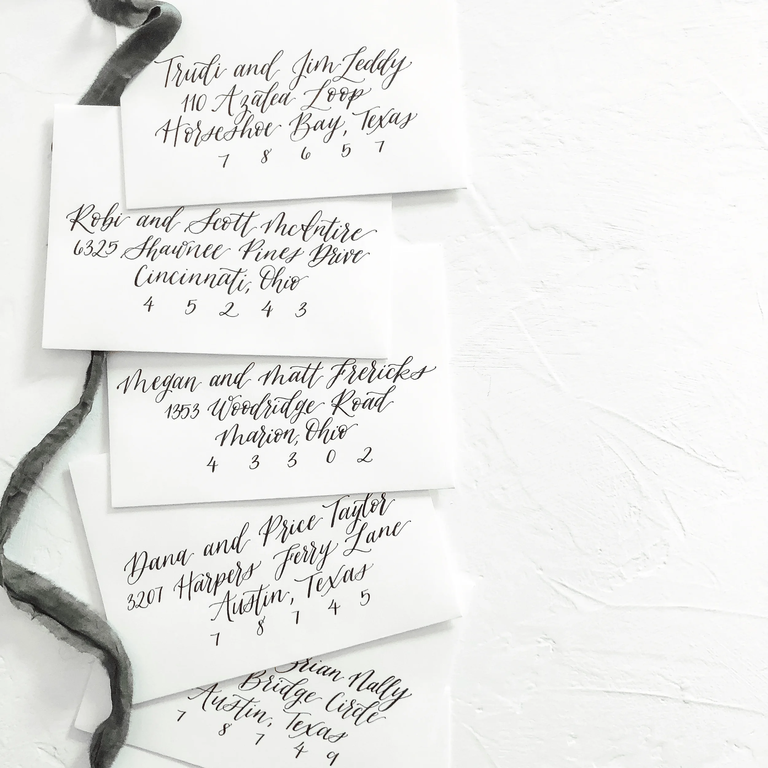 For the ultimate timeless aesthetic, opt for classic black script calligraphy envelope addressing. This clean, high-contrast style on bright white paper features sweeping cursive ascenders and precise spacing, making it perfect for formal estate or c